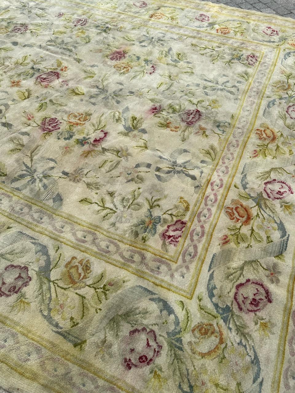 Voici un superbe tapis français d'Aubusson, au design floral exquis et aux couleurs douces et claires. Ce magnifique grand tapis est méticuleusement noué à la main avec du velours de laine sur une base de coton. Le fond arbore une gracieuse teinte