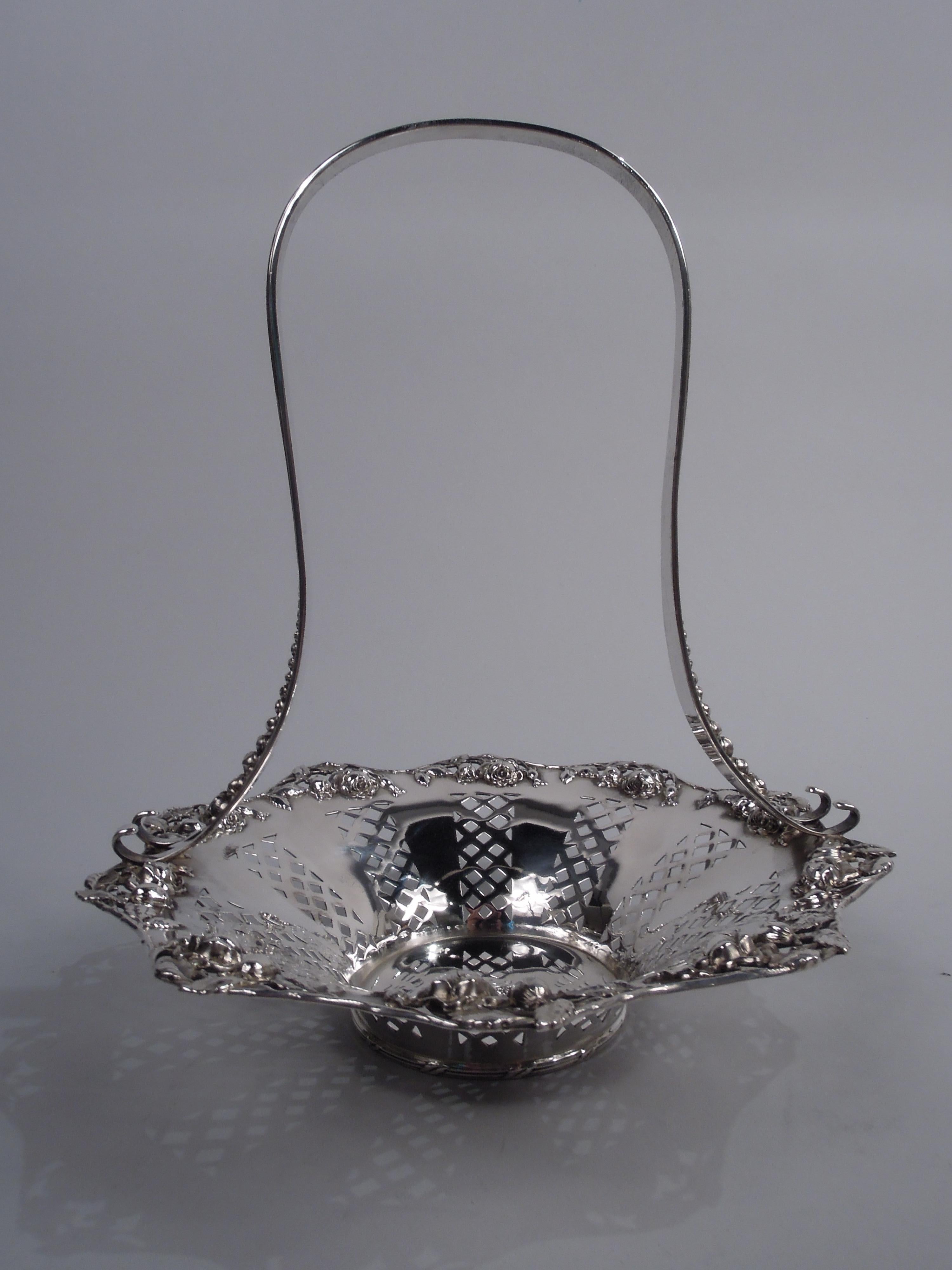 Pretty Edwardian sterling silver basket with roses. Made by Tiffany & Co. in New York. Circular well with flared sides and wide mouth. Sides have alternating solid and pierced trellis. Scrolled and wavy rim in form of flowering rose vine with both