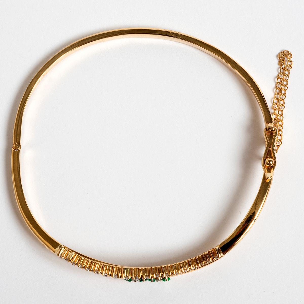 A unique piece within our carefully curated Vintage & Prestige fine jewellery collection, we are delighted to present the following: This pretty diamond and emerald bangle is set within 9 carat yellow gold. This bangle measures 60 mm x 55mm and