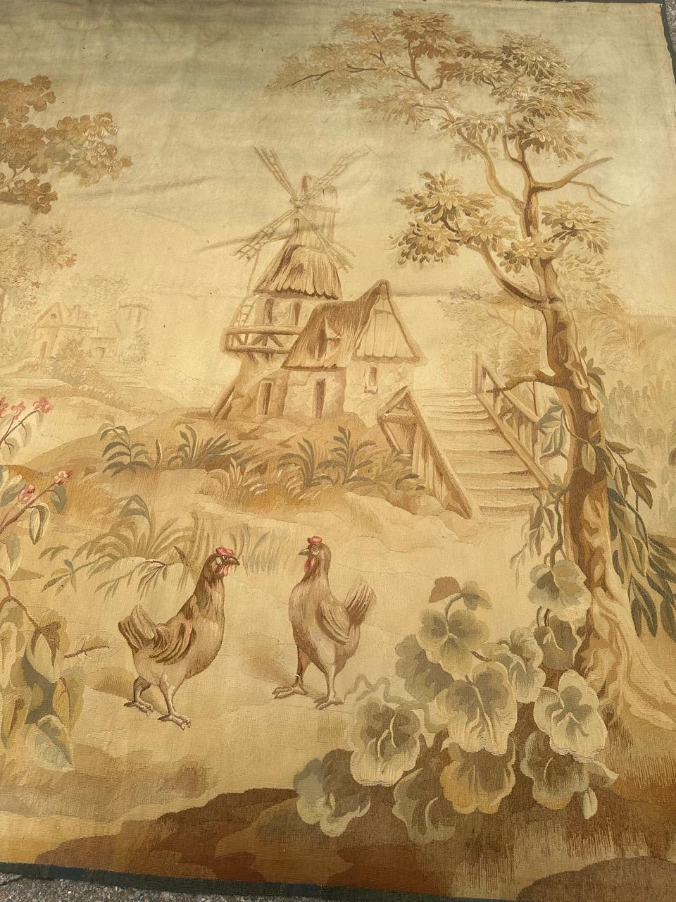 Precioso tapiz de Aubusson francés de finales del siglo XIX con un bonito diseño de un pueblo, con naturaleza, árboles, pájaros, un río, gallinas. un molino en la orilla del río, casas de pueblo al otro lado y en la distancia. todo en colores