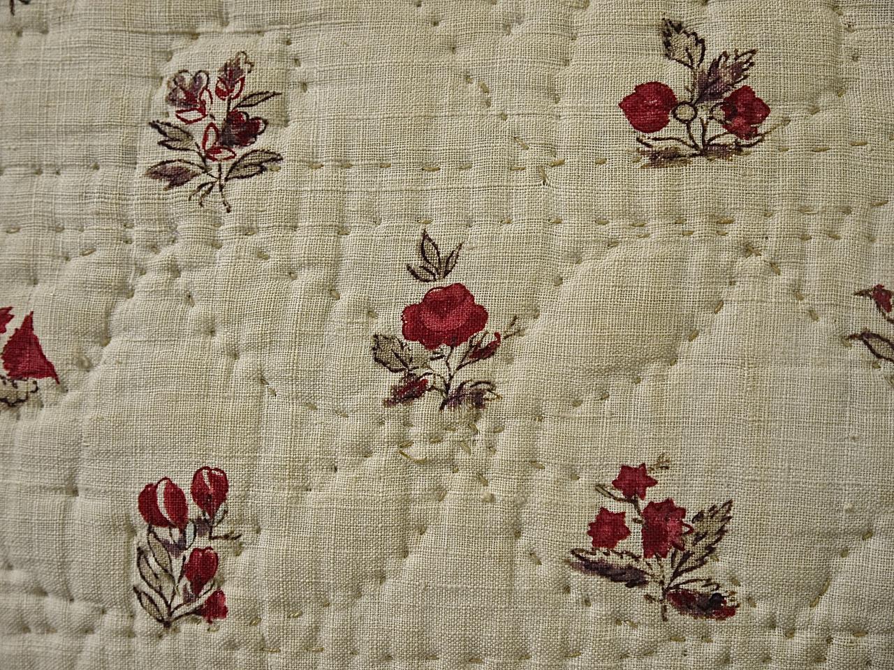 18th century French soft cotton cushion block printed with delicately drawn flower motifs. Soft raspberry pink and pale blue flowers with green leaves and stems make a fresh and charming textile. Simply quilted in a pattern of circles and stylized