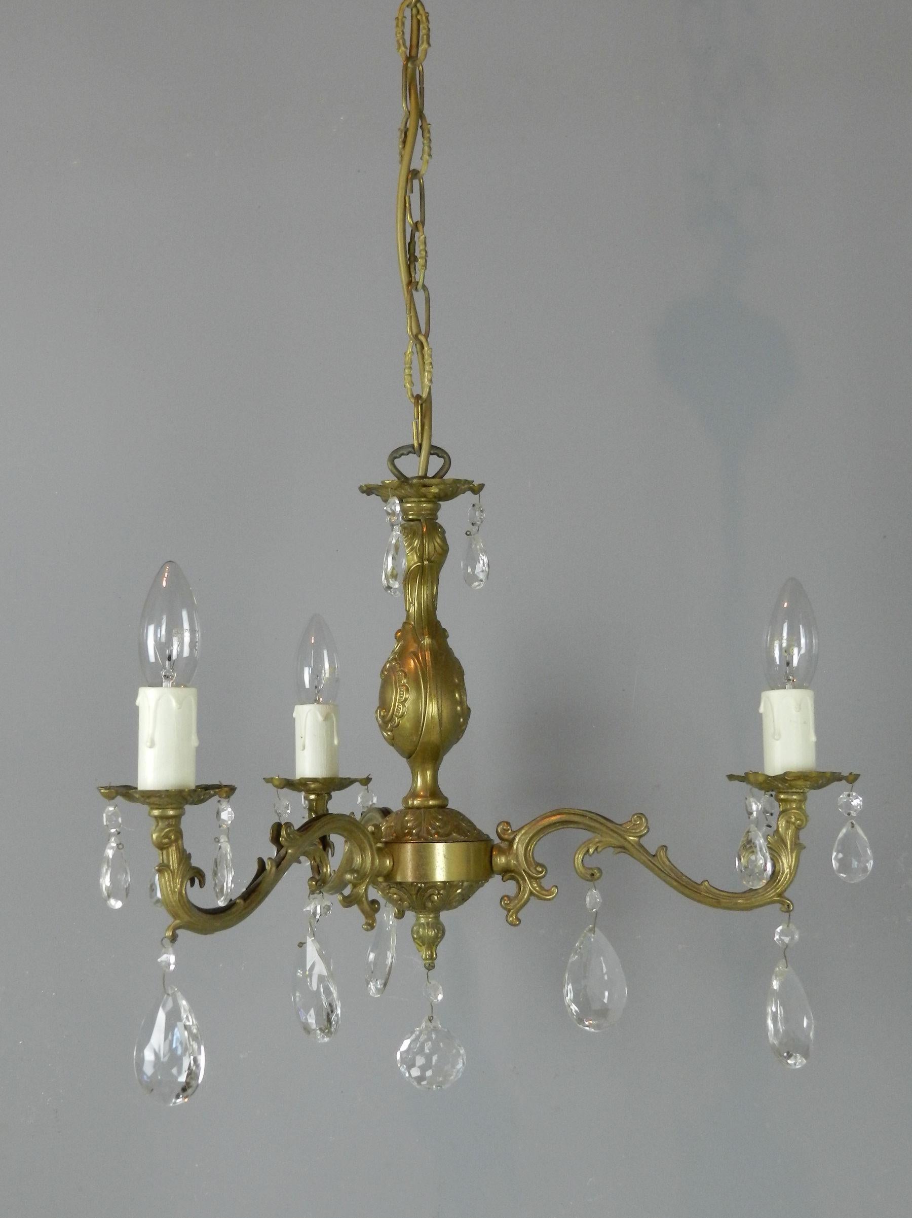 A Pretty French chandelier & matching wall sconces cast in decorative gilt metal. The chandelier has 3 s scroll out swept arms holding the candlelight bulbs. 

The whole chandelier is decorated with multifaceted glass pendants. All suspended on