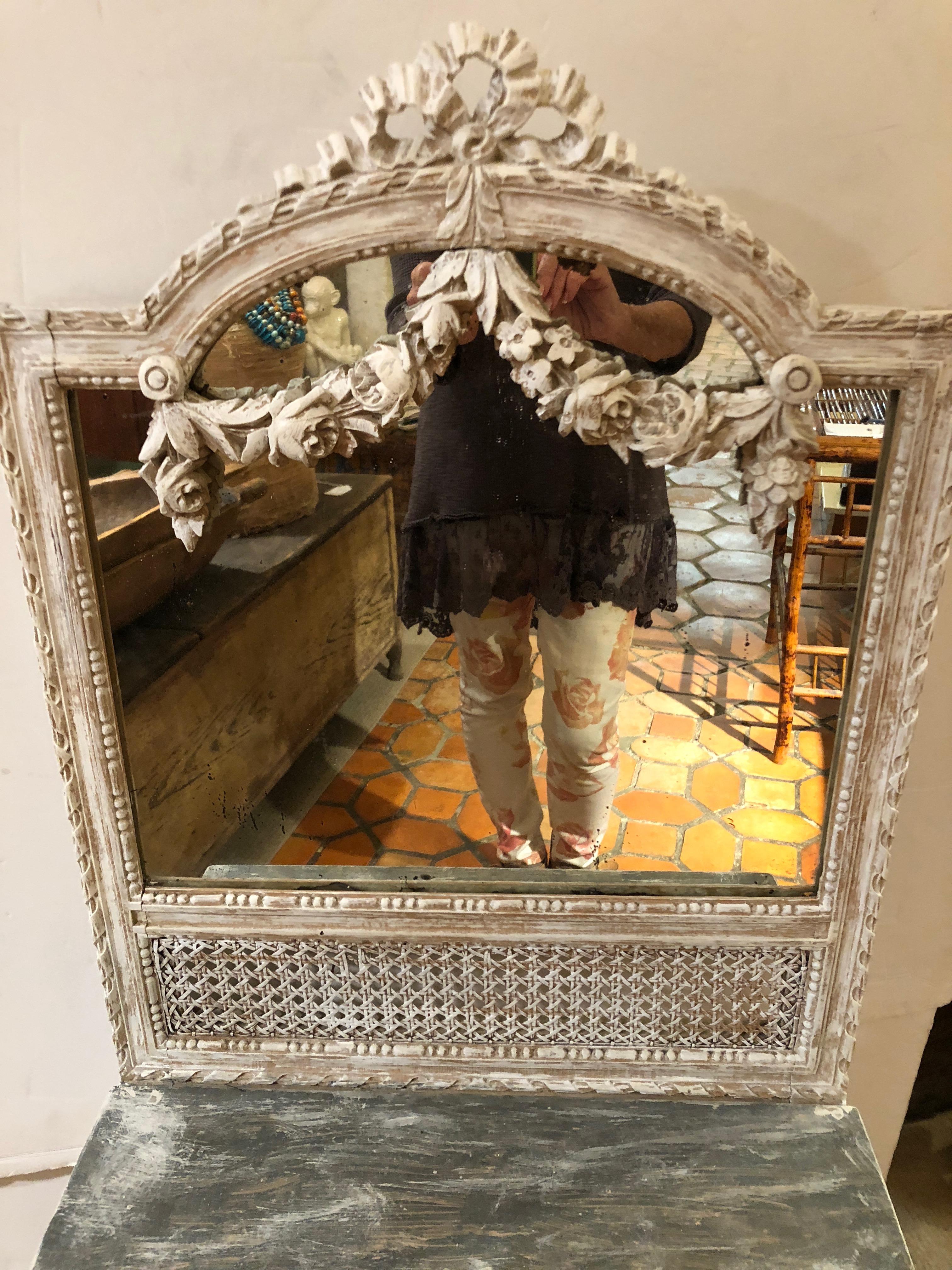 Lovely off white and natural carved wood Louis XVI style vanity console or dressing table having bow and garland, caned detailing, and a faux painted surface that looks like marble.
Measures: Writing surface is 29 H, 9 D.