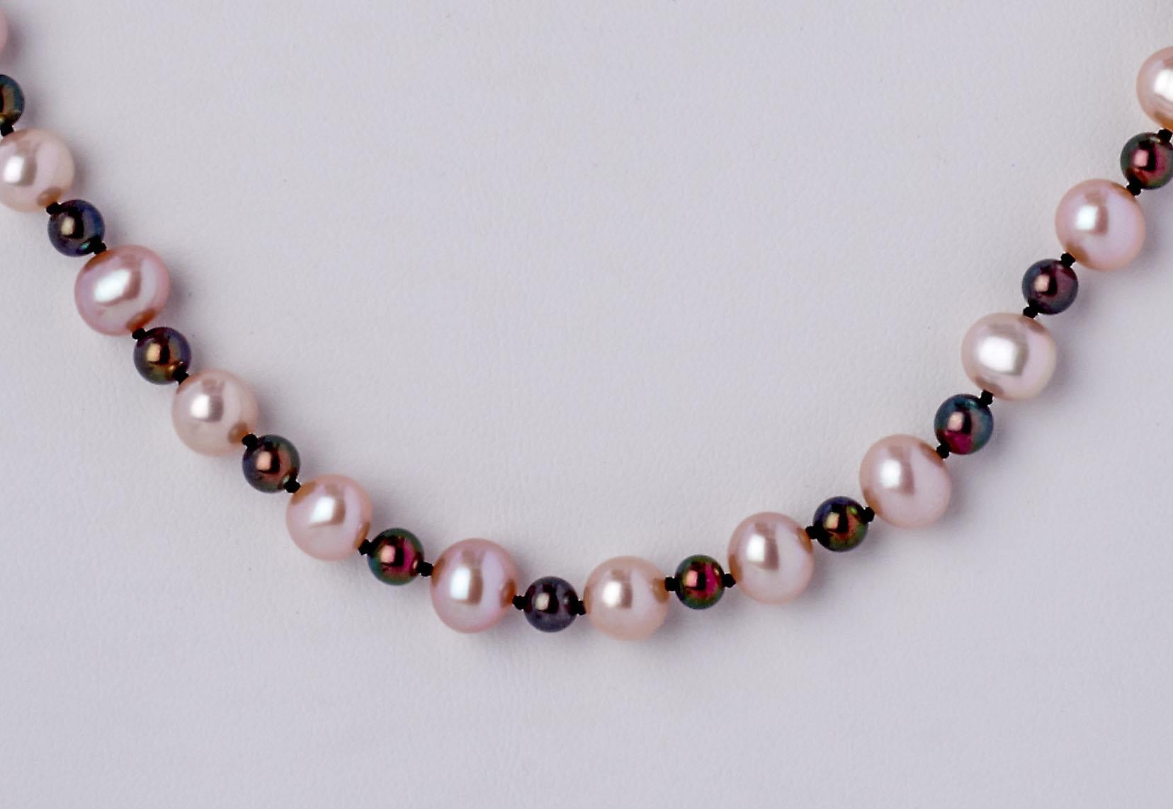Soft shades of pink radiate from this pretty 24 inch pearl necklace, hand-strung with 7mm off round blush color freshwater pearls alternating with 4.25mm soft gray hematite beads. New, this piece is finished with a sterling silver & crystal clasp.