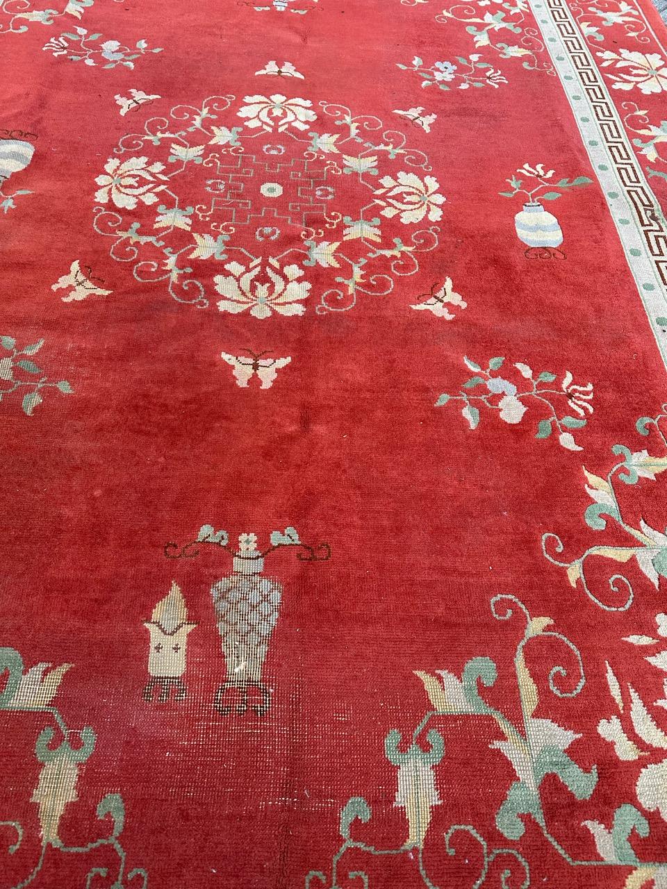 Beautiful large vintage Chinese rug from the mid-20th century, entirely hand-knotted in wool on a cotton foundation. Art Deco-inspired design featuring a red background with a medallion adorned with stylized flowers and branches in white and light