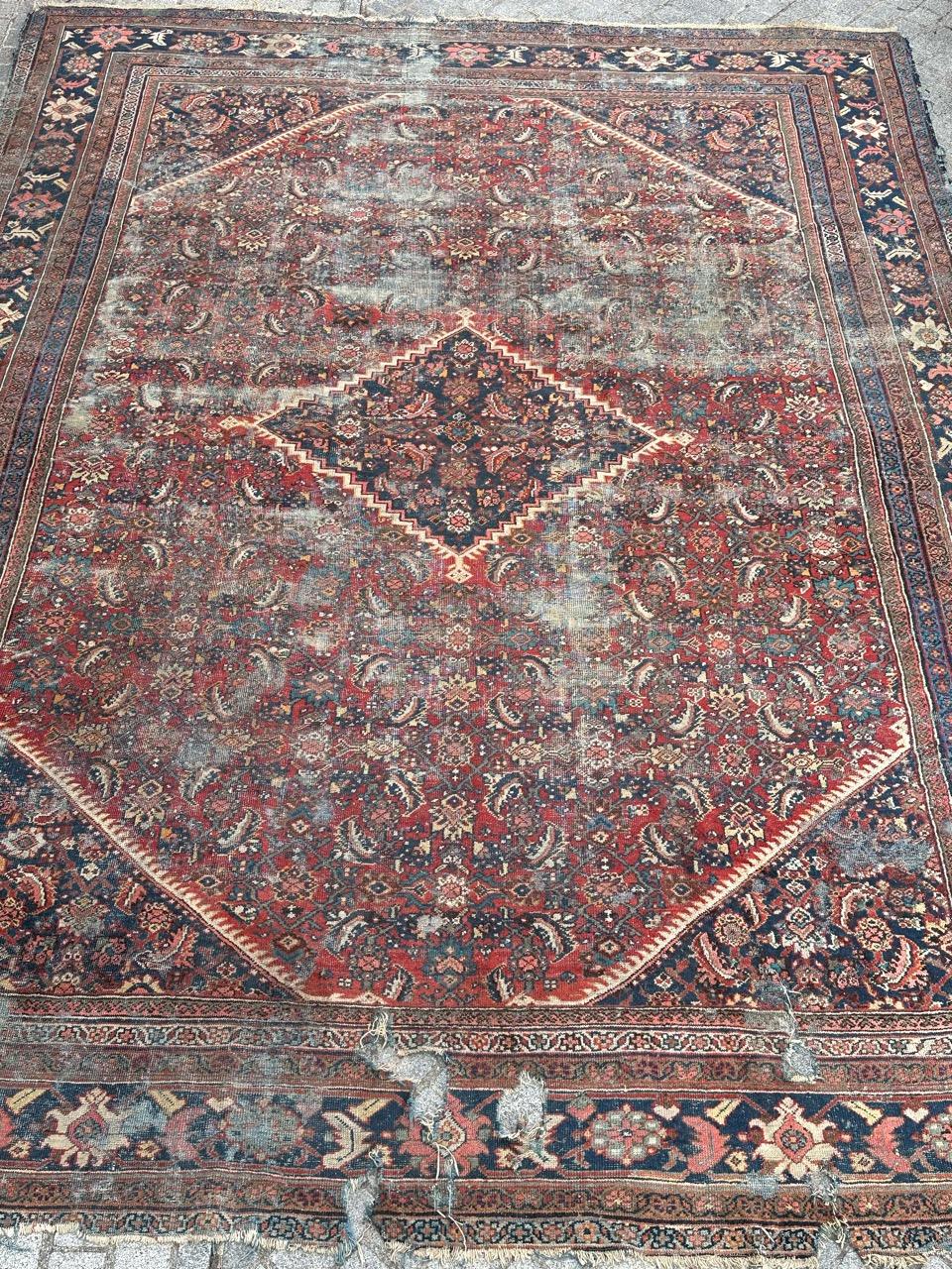 Presenting an exquisite antique distressed rug! Graced with a splendid Mahal design adorned by intricate Herati motifs, highlighted by a striking deep blue central medallion and main border, set against a field of rich red. This masterpiece is