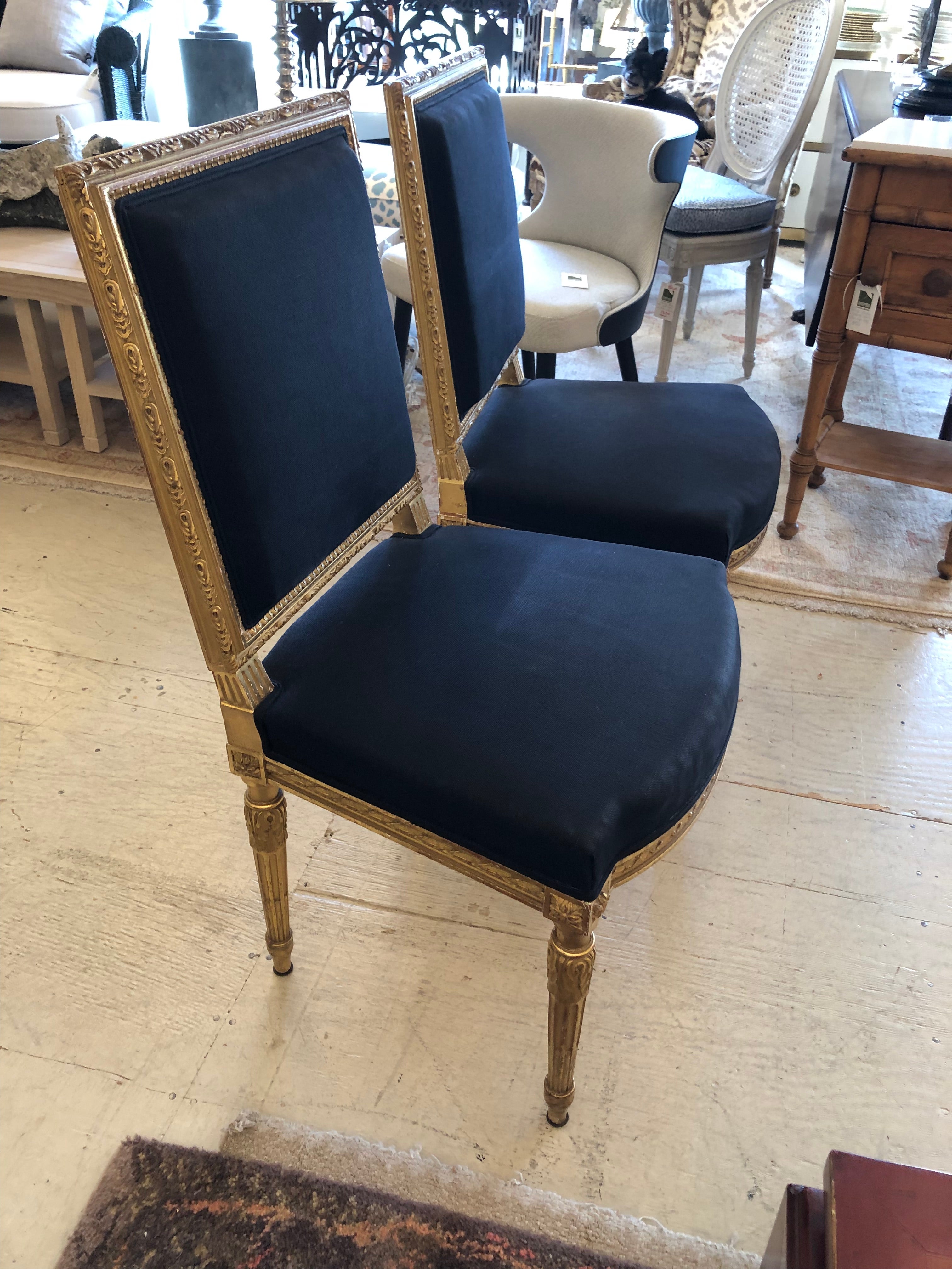 Pretty and classic antique Louis XVI style French fauteuils having slightly chippy gorgeously aged giltwood frames and navy blue upholstery.  

Kamille