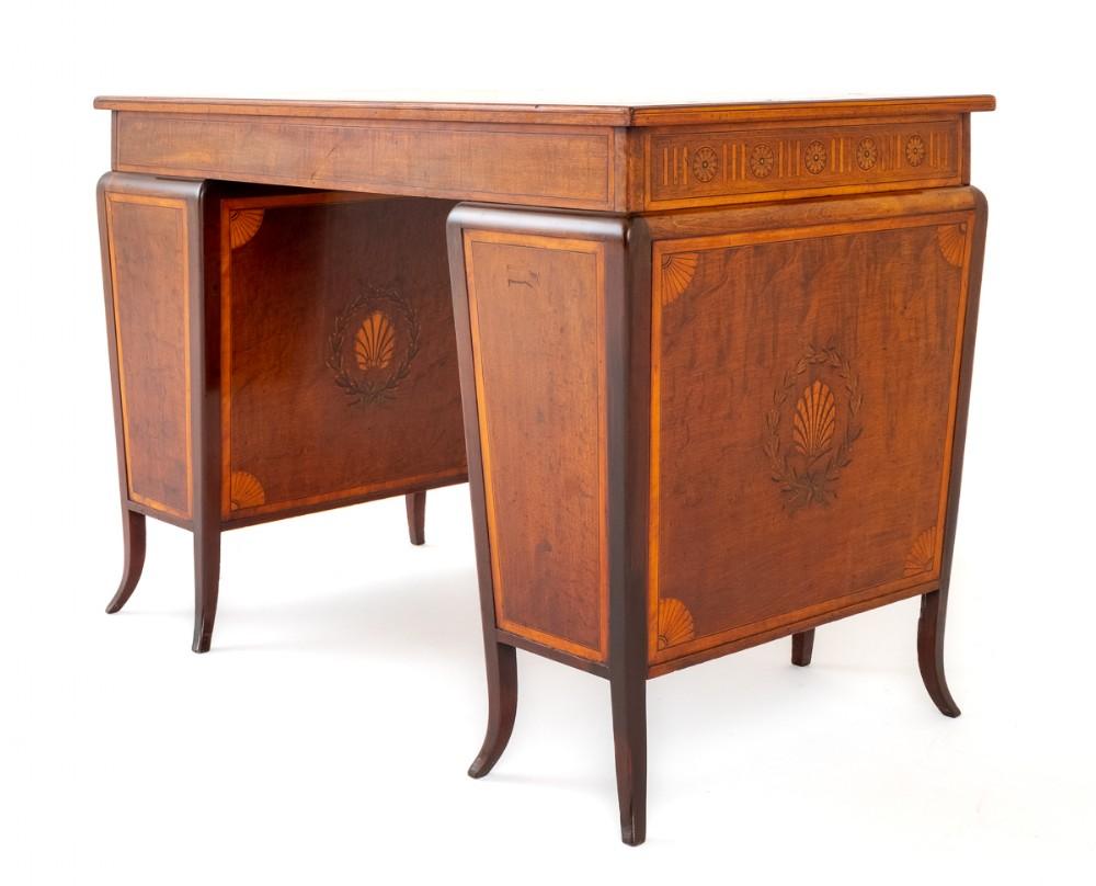 Pretty mahogany Sheraton revival pedestal desk.
This desk stands upon shaped legs.
Each pedestal featuring 3 graduated mahogany lined drawers.
The drawer fronts having teardrop brass handles and inlaid bows and swags.
The frieze of the desk