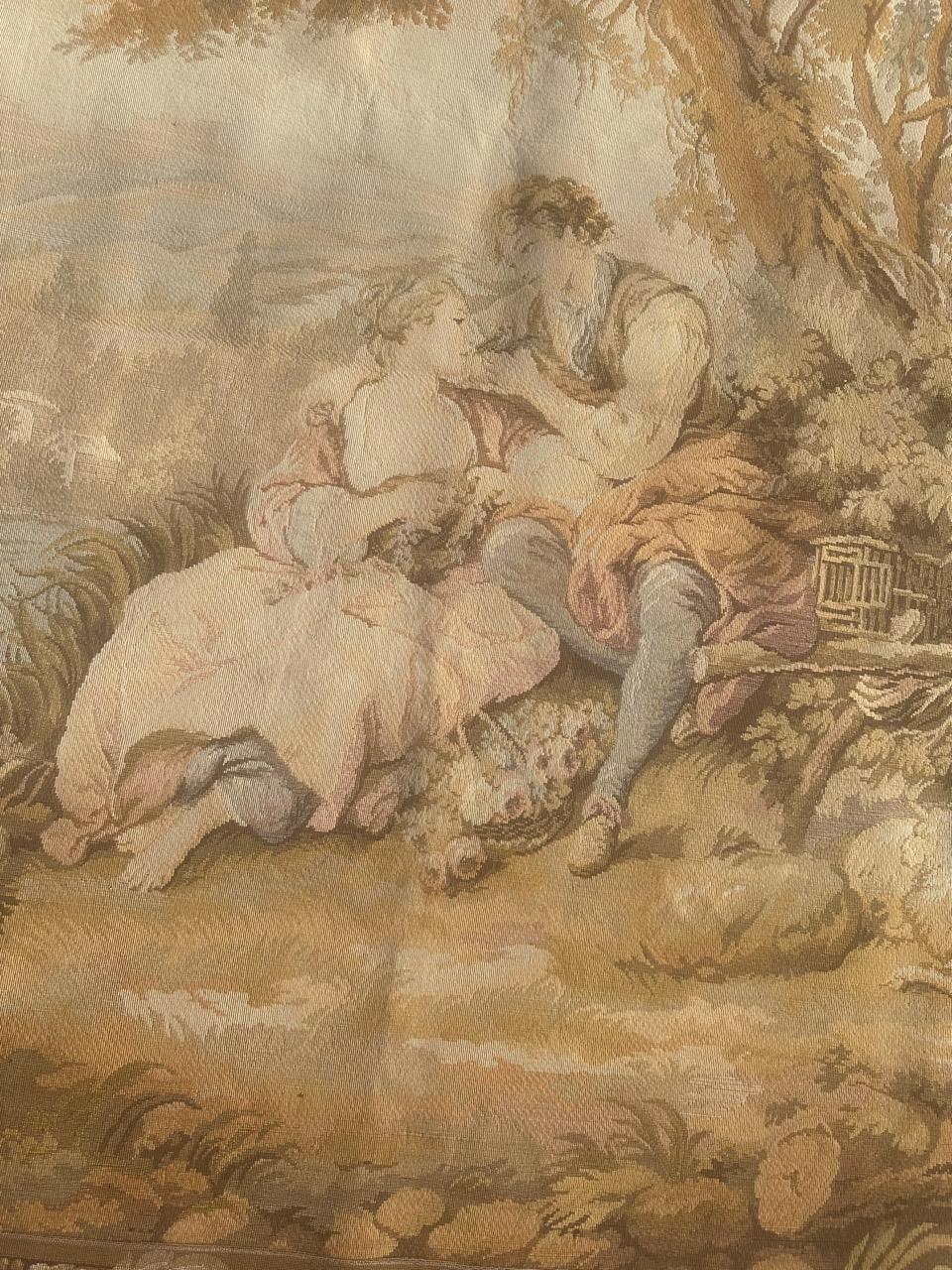 Elevate your space with this exquisite Aubusson-style tapestry featuring a romantic depiction of a loving couple in the countryside, nestled under a tree. Sheep graze nearby, and a gentle river flows in the background. The soft hues of yellow, light