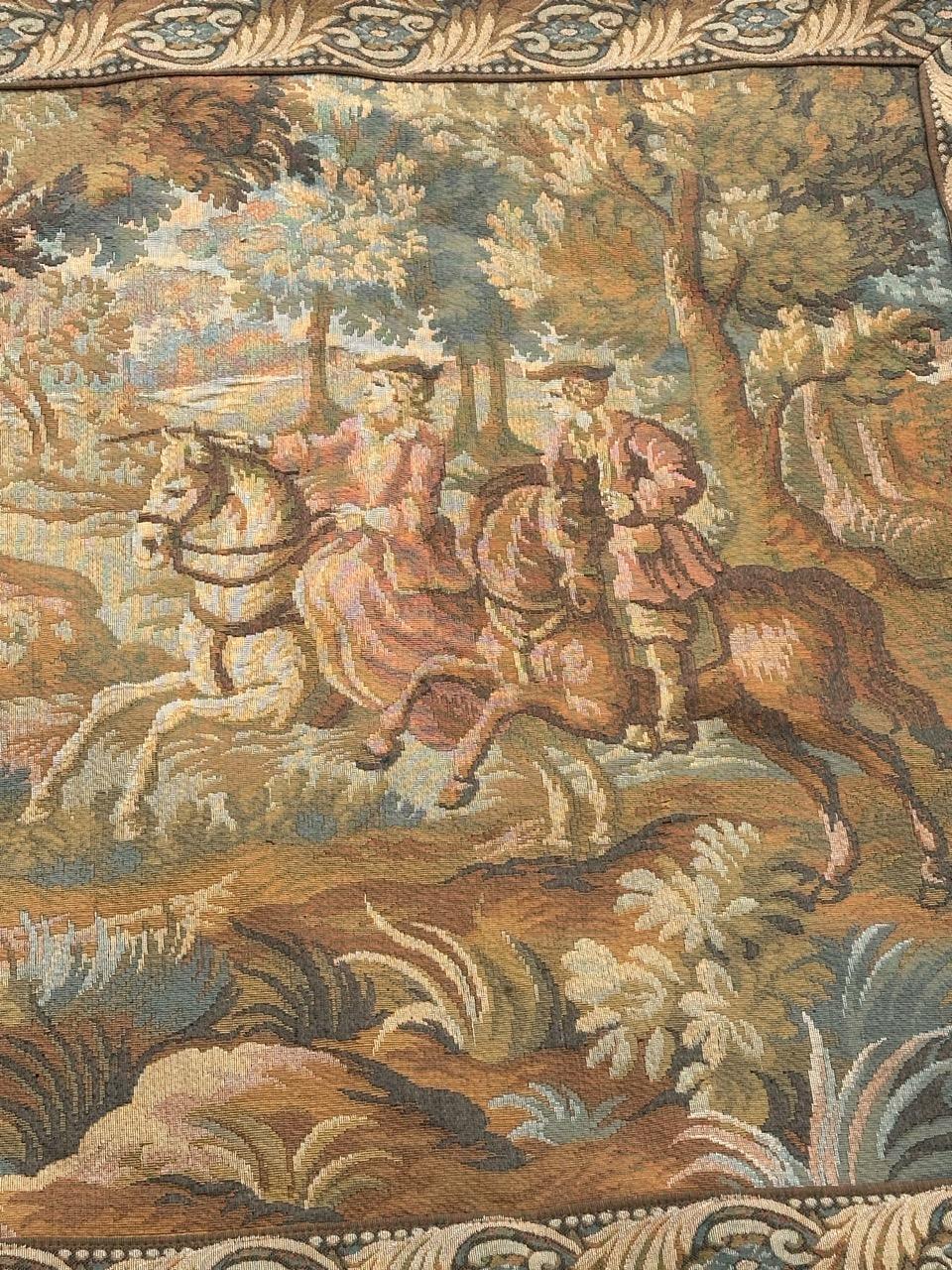 Elevate your space with this exquisite Aubusson-style tapestry with a design of wild boar hunting, in the middle of the trees, two hunters on horseback, on one side, and hunting dogs who surround the trapped wild boar, on the other side. The soft