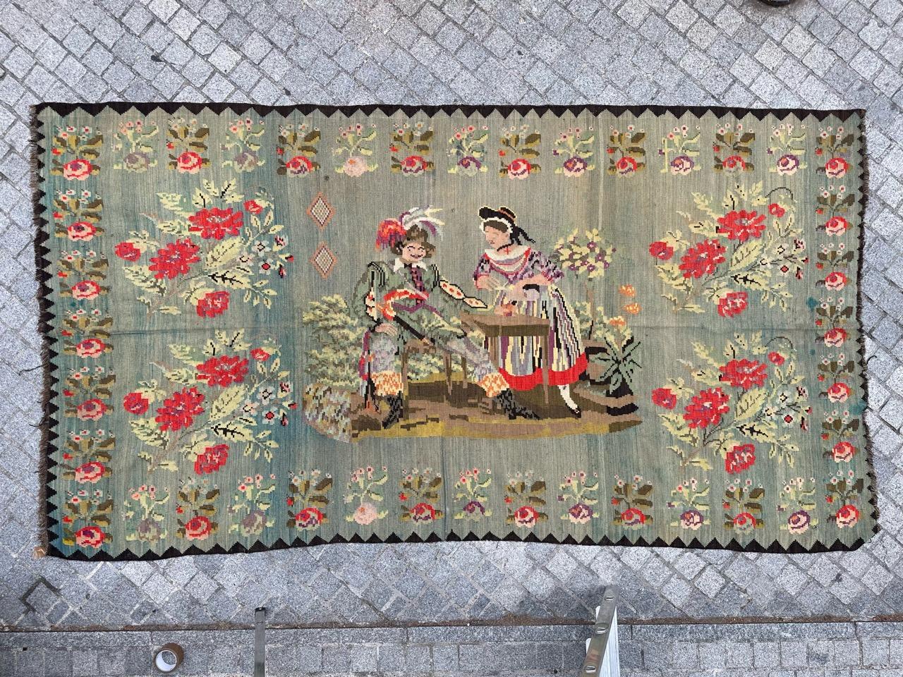 Introducing a stunning vintage Karabagh tapestry or Kilim: A true masterpiece of craftsmanship. This exquisite piece features an intricate design portraying a couple surrounded by vibrant flowers, woven entirely by hand using wool on a wool