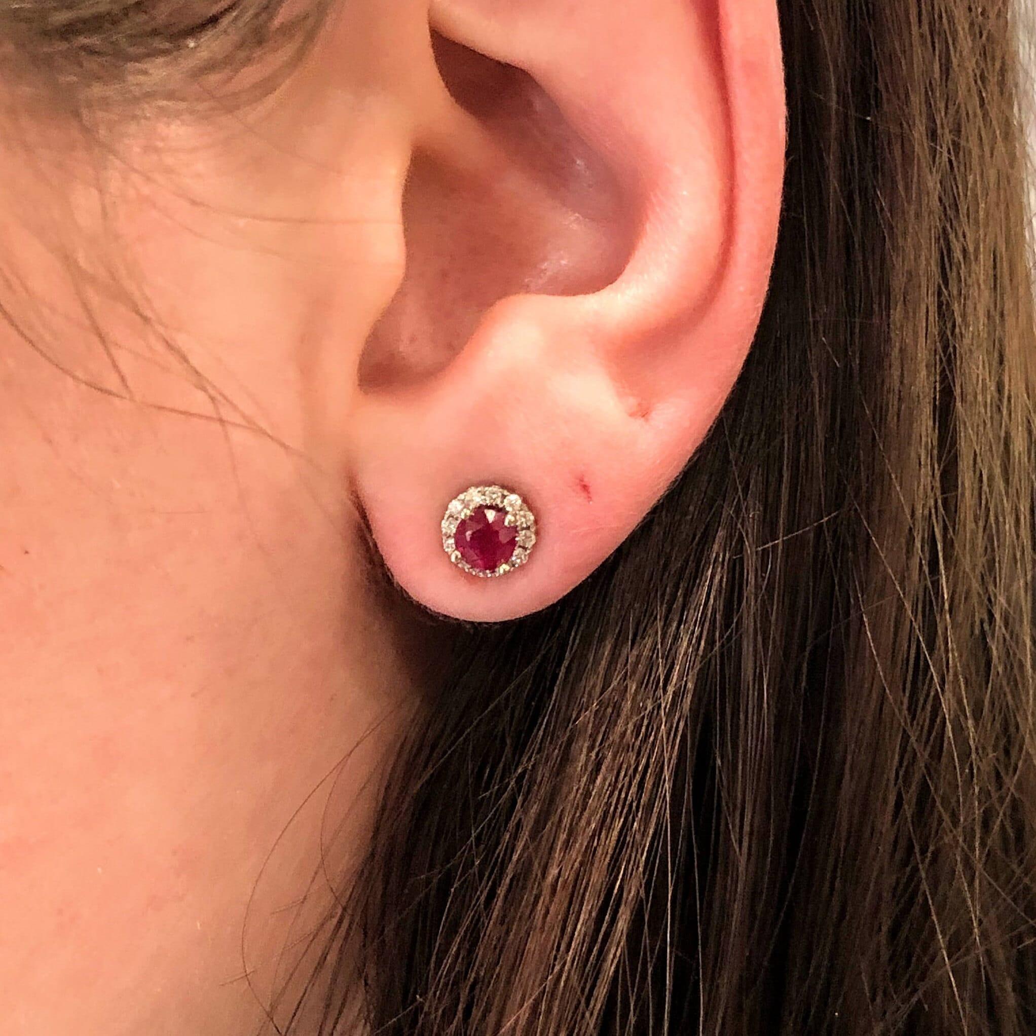 These dainty studs feature rich round Mozambique rubies surrounded by a halo of natural earth-mined diamonds, all set in solid 14k white gold. Finished with secure butterfly pushbacks, they're a timeless gift for her—perfect for birthdays or