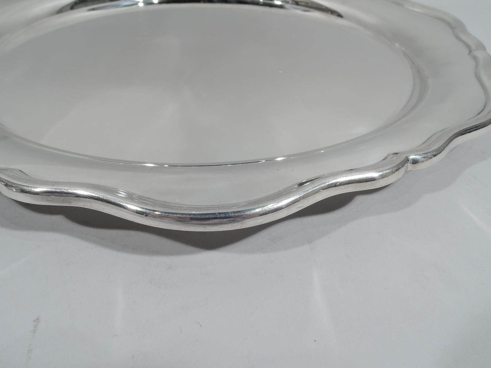Elizabeth II sterling silver serving tray. Made by Edward Viner in Sheffield in 1960. Round with well and molded and gently scrolled rim. Pretty and old fashioned. Fully marked. Weight: 33 troy ounces.