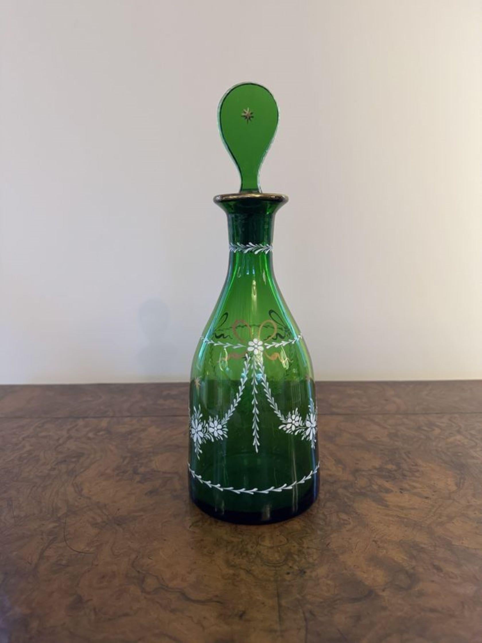 Jolie paire de carafes à décanter antiques. Jolie paire de carafes à décanter antiques en verre vert, peintes à la main avec des fleurs et des nœuds en blanc et or, avec les bouchons en verre plat d'origine.

D. 1900