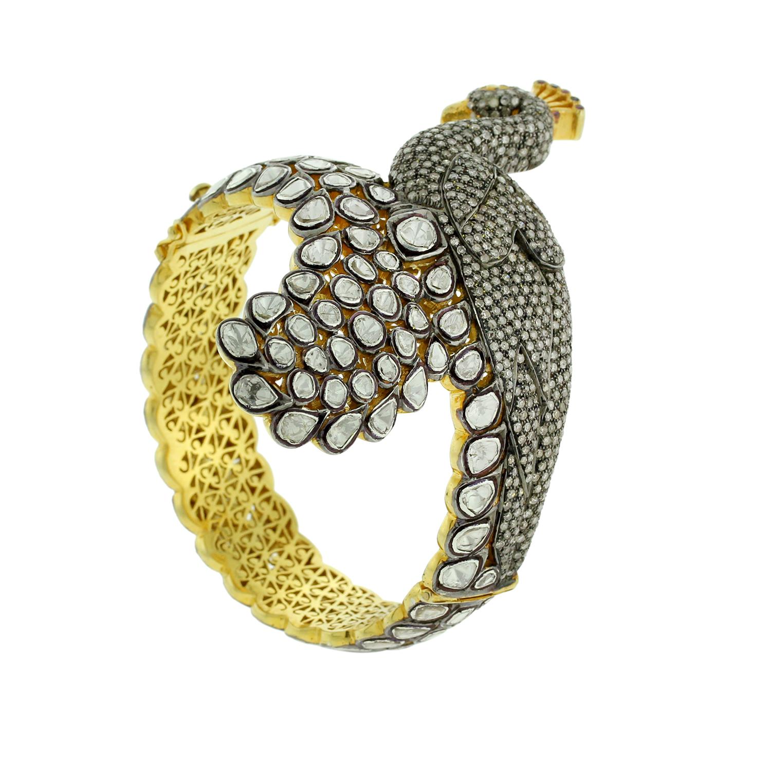 Pretty Peacock bangle in Silver and Gold with rosecut diamonds a unique blend of modern and traditional look. This bangle can be opened on side and very beautifully handcrafted. 

14KT: 19.04gms
Diamond: 13ct
SiIver: 60.97g
RUBY: 0.43ct 
