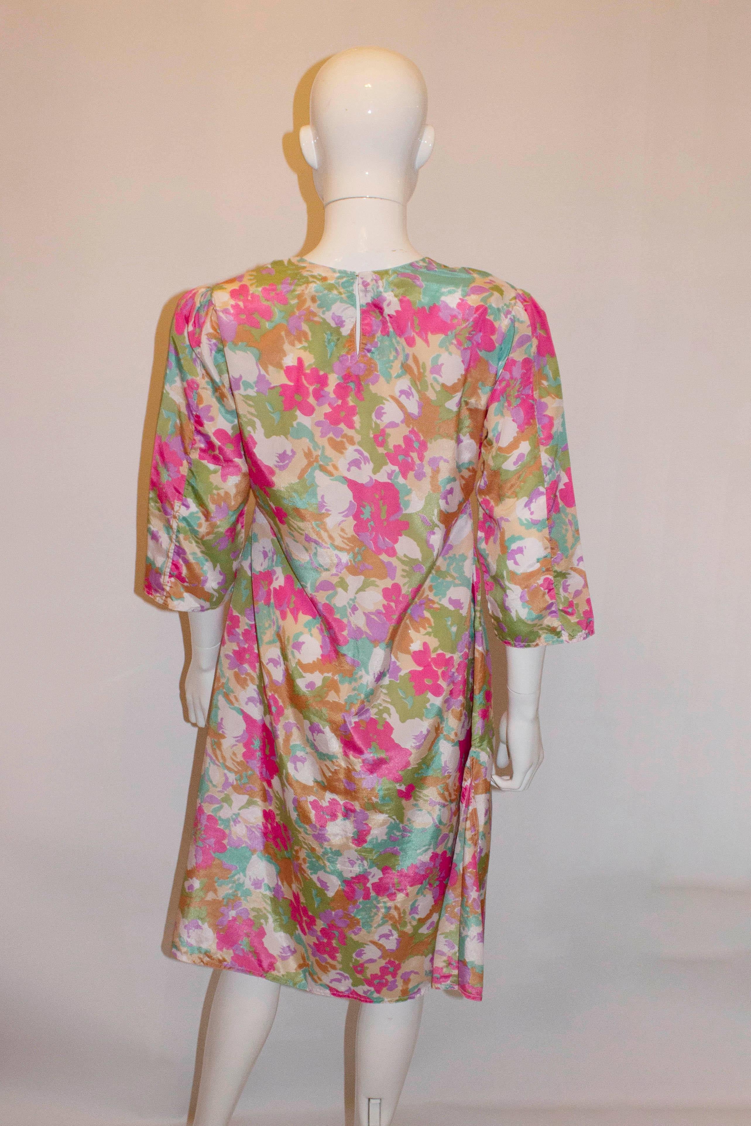 A pretty vintage print shift dress. The dress has a three button decoration at the front , a round neckline with opening at the back and 15'' slits  on either side.