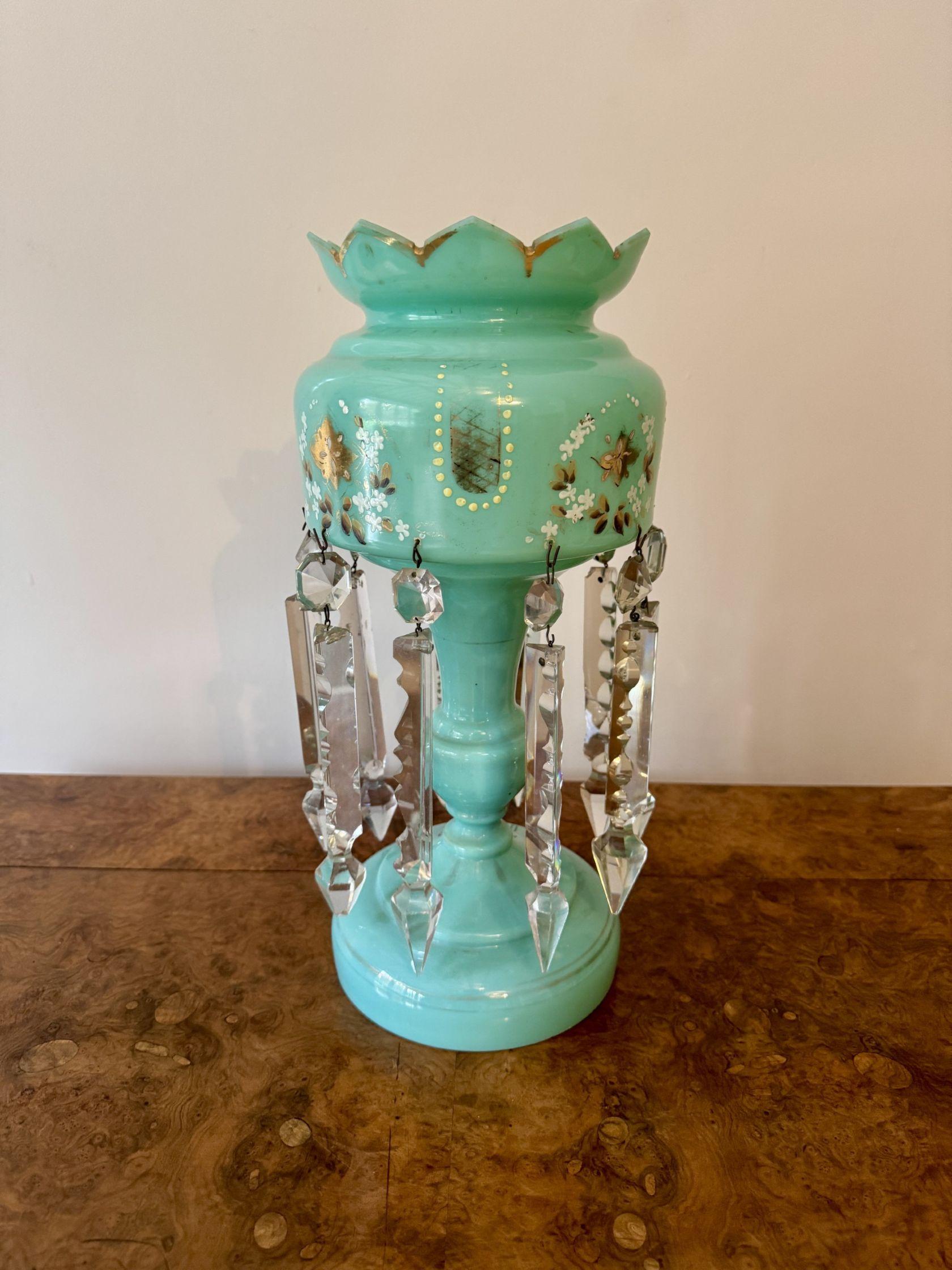 Un lustro di vetro turchese antico di grande qualità, con la parte superiore decorata con fiori e foglie dipinti a mano in bianco e verde con dettagli dorati in oro, con le gocce prismatiche originali in vetro argilloso.

D. 1860 