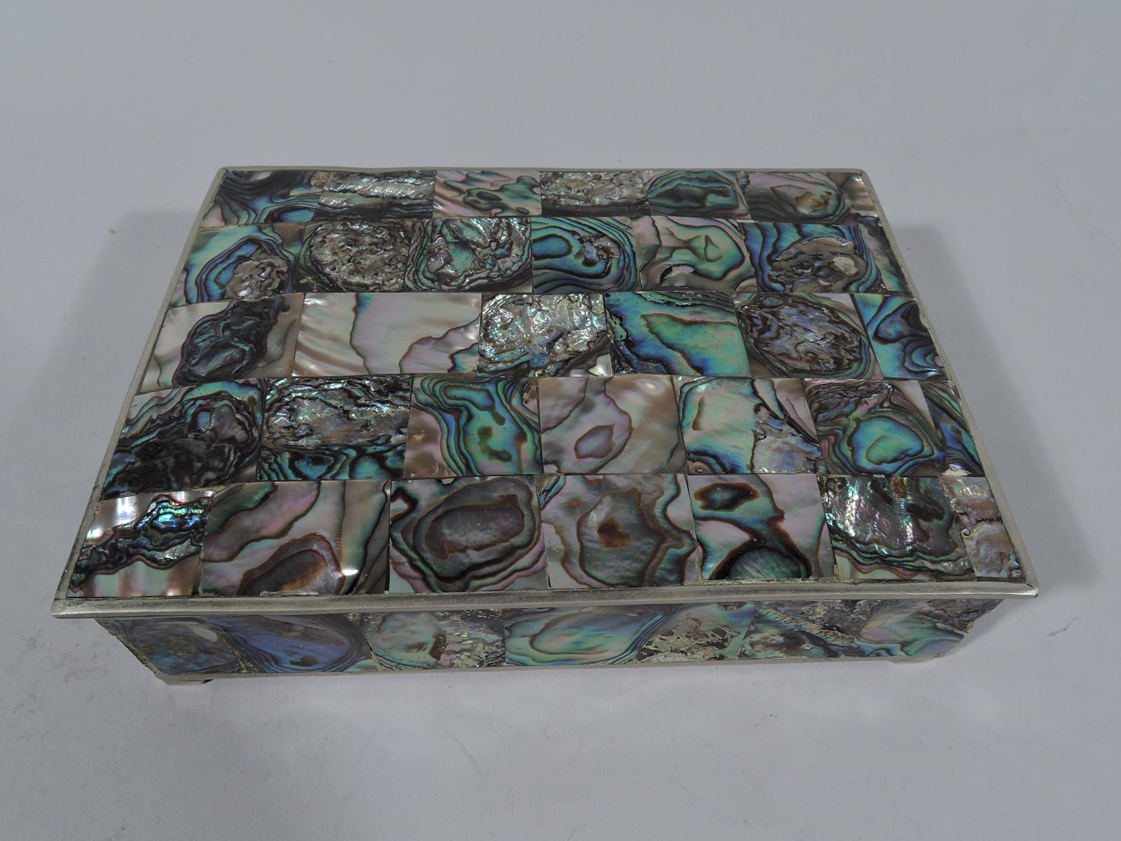Mexican trinket box, circa 1950. Low and rectangular with corner bracket supports. Cover hinged and gently curved with overhang. Luminous and irregular abalone veneer in form of square tesserae applied to sides and cover top. Box interior lined with