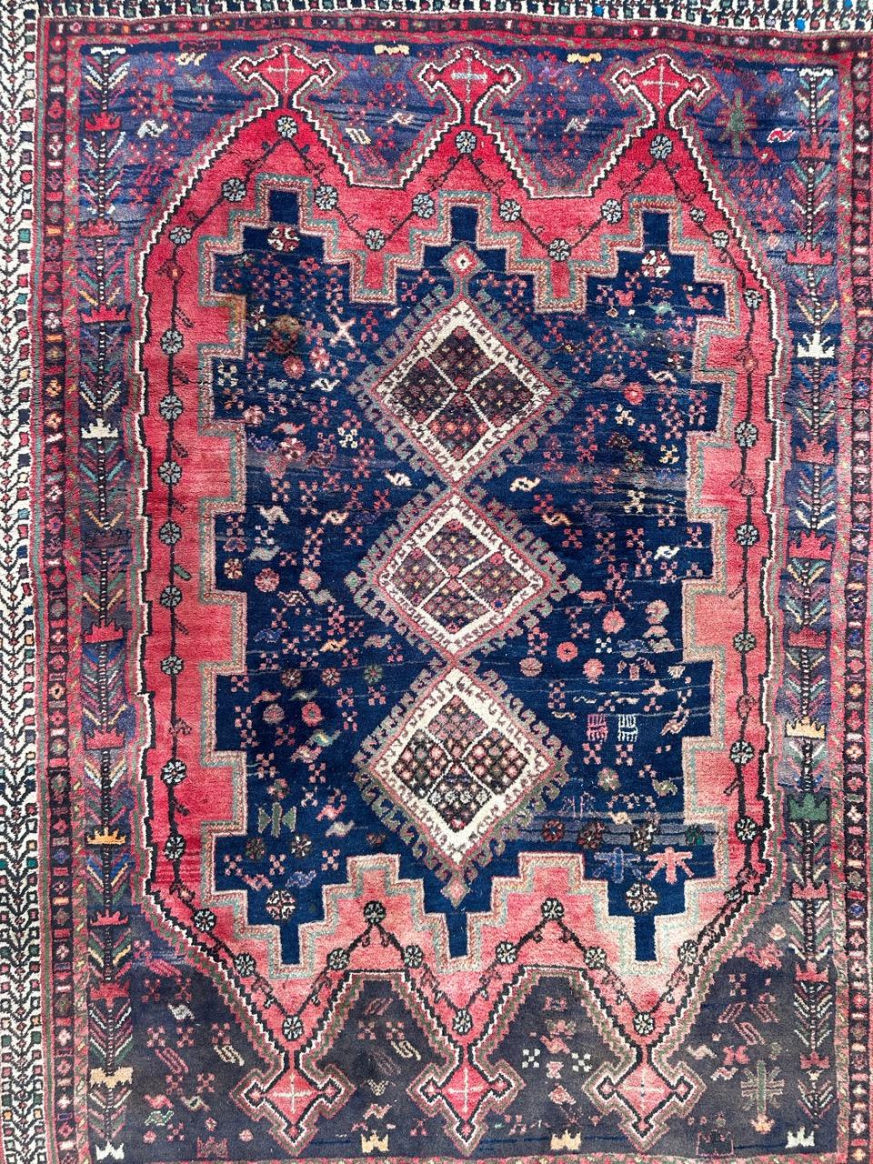 This exquisite handwoven Afshar rug features a stunning decorative and geometric design. At its heart, you'll find three successive diamond-shaped medallions on a pristine white background, each adorned with elegant brown stylized floral patterns.