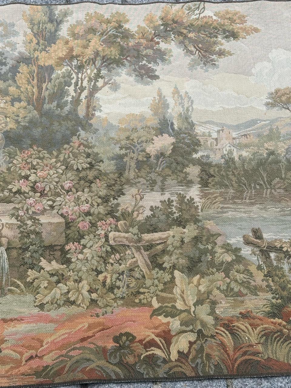 Belle tapisserie vintage française de style Aubusson avec un joli dessin de la nature avec des arbres, de la végétation et une rivière, une fontaine d'eau avec des statues d'anges. et plus loin, une maison avec un moulin à eau. et avec de belles