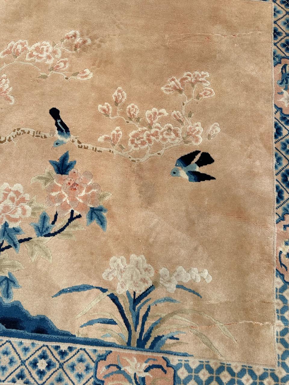 Joli tapis chinois vintage de Pékin avec un joli motif décoratif de style art déco représentant la nature avec des arbres stylisés, des oiseaux, des fleurs, et de belles couleurs avec un fond orange délavé, bleu et marron, entièrement noué à la main