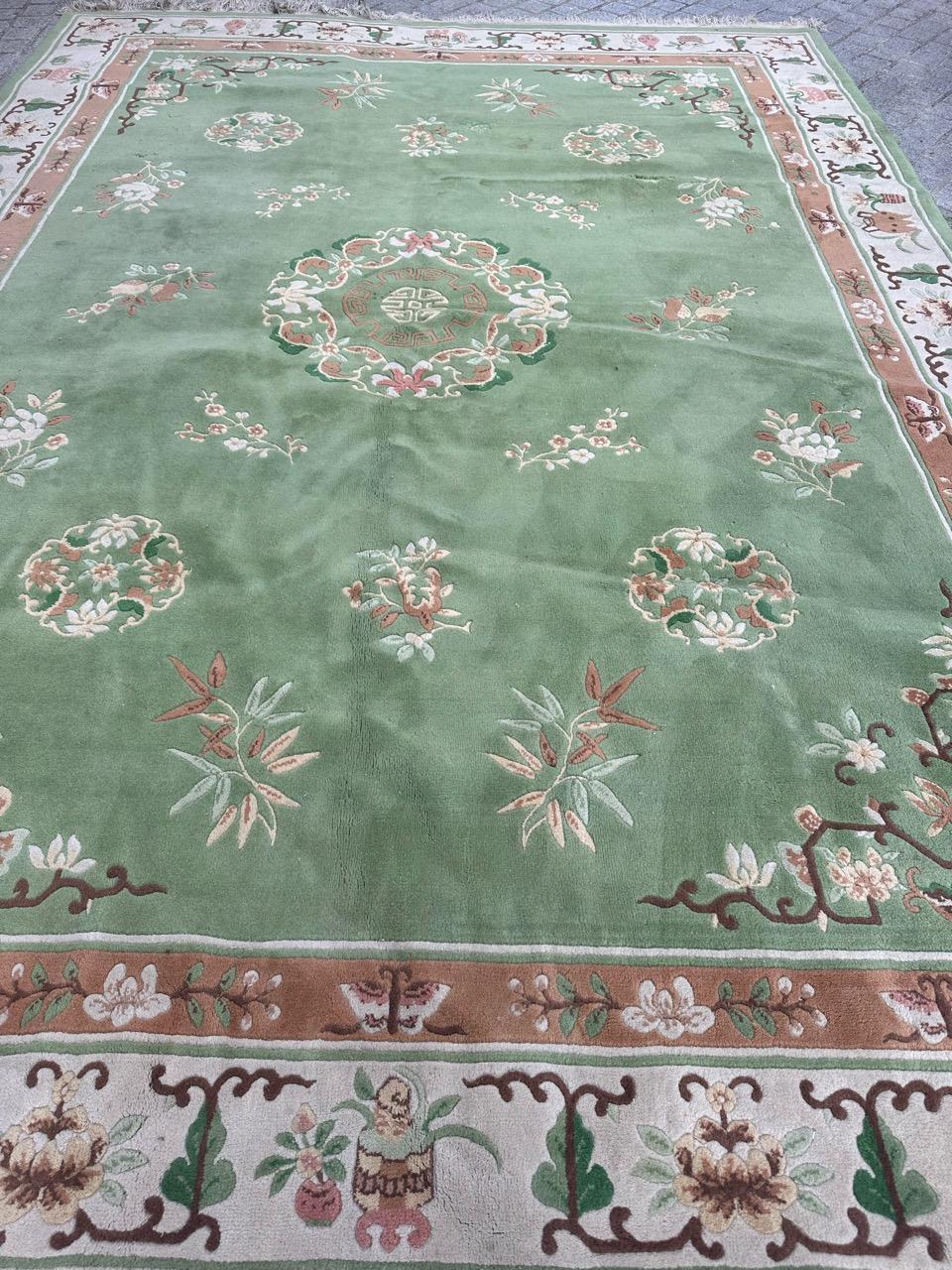 Wir präsentieren einen bezaubernden chinesischen Teppich aus der Mitte des Jahrhunderts mit einem fesselnden chinesischen Art-Déco-Design. Der Teppich zeichnet sich durch eine harmonische Mischung von Farben aus, darunter ein faszinierendes grünes