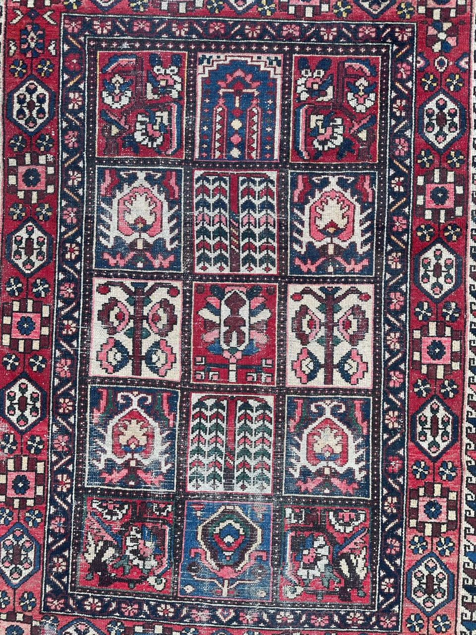 Beautiful vintage distressed Bakhtiar rug with a beautiful geometrical and stylized design with blue red, pink and green.uniform wears. Entirely hand knotted with wool velvet on cotton foundation 

