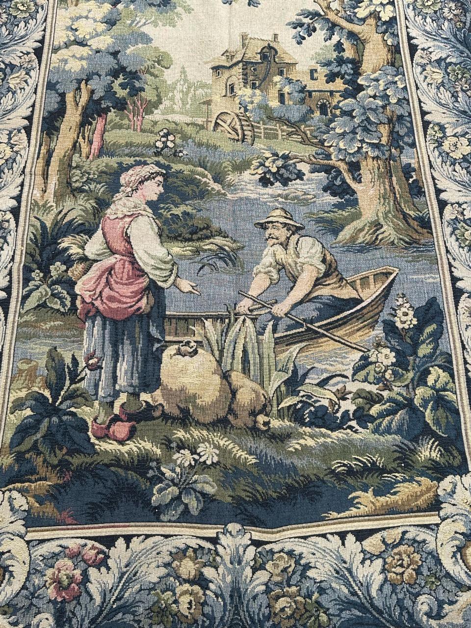 Descubre el exquisito encanto de este tapiz francés de mediados del siglo XX, meticulosamente tejido en telares Jacquard en talleres franceses. Confeccionado con una mezcla de algodón y lana, captura un  diseño con un barquero hablando con una mujer