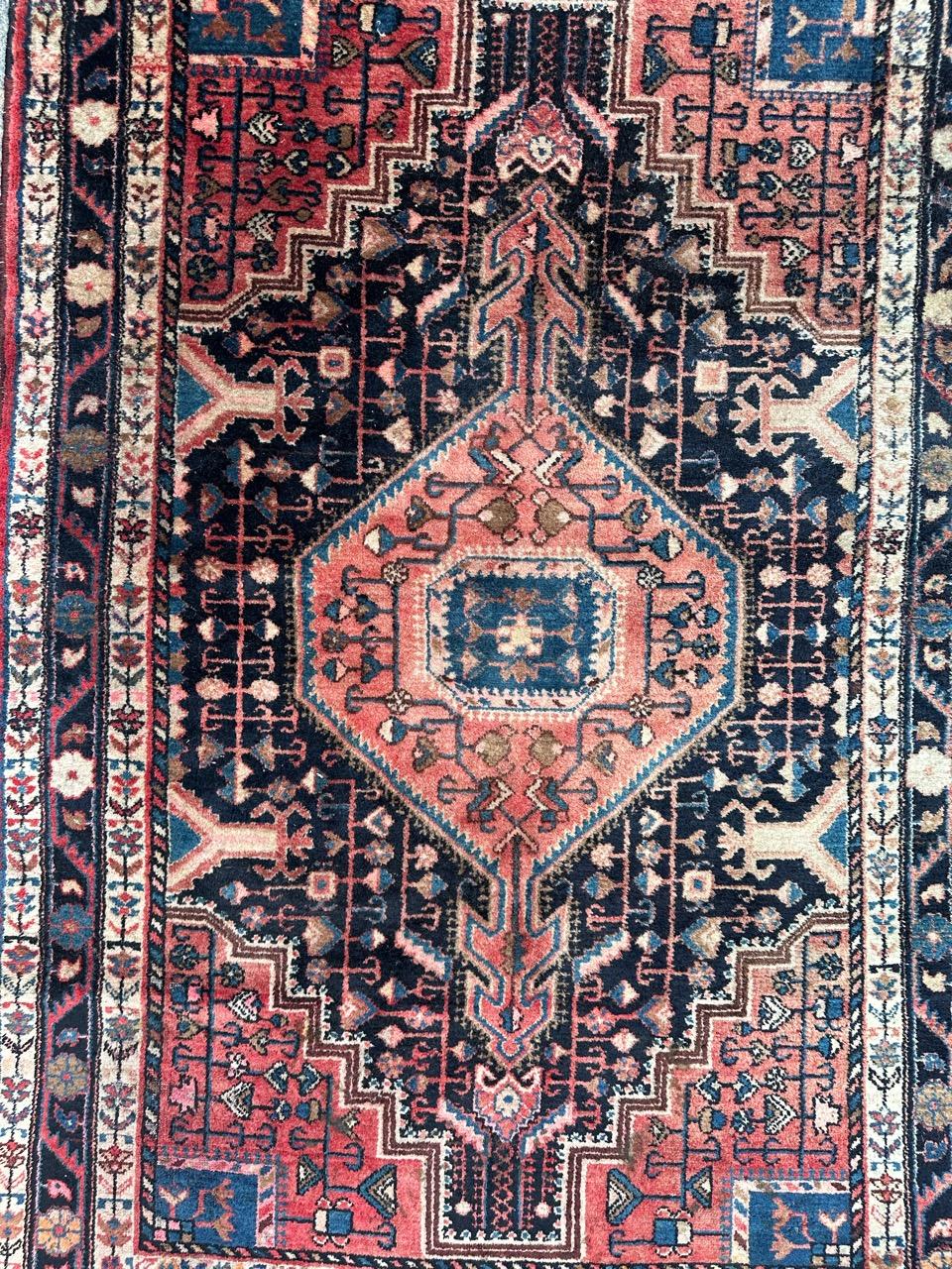 Beautiful mid-20th century Hamadan rug, entirely handwoven in wool on a cotton foundation. Featuring intricate geometric and stylized patterns in lovely colors. The deep blue field of the rug is adorned with a large rosy-red medallion, enclosing a