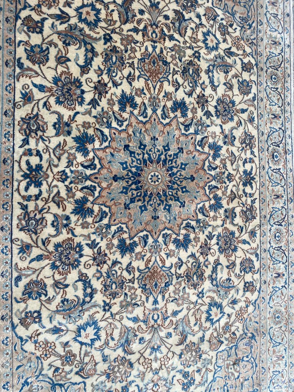 Nice vintage Nain rug with beautiful floral design and nice light colors, entirely and finely hand knotted with wool and silk on cotton foundation.