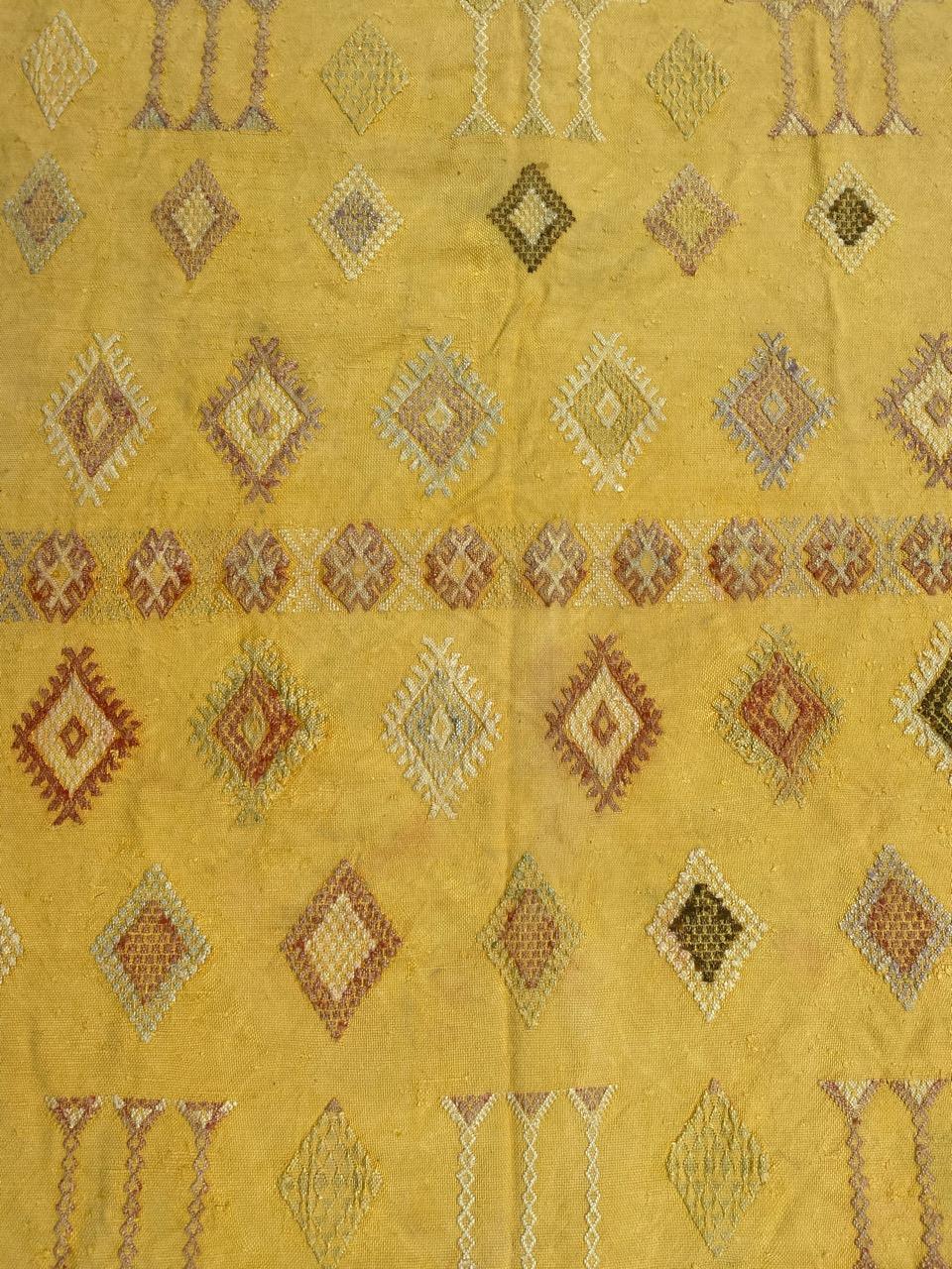 Kilim berbère marocain du milieu du siècle avec un design tribal et de belles couleurs avec un champ de couleur jaune, entièrement tissé à la main avec de la soie et du coton.