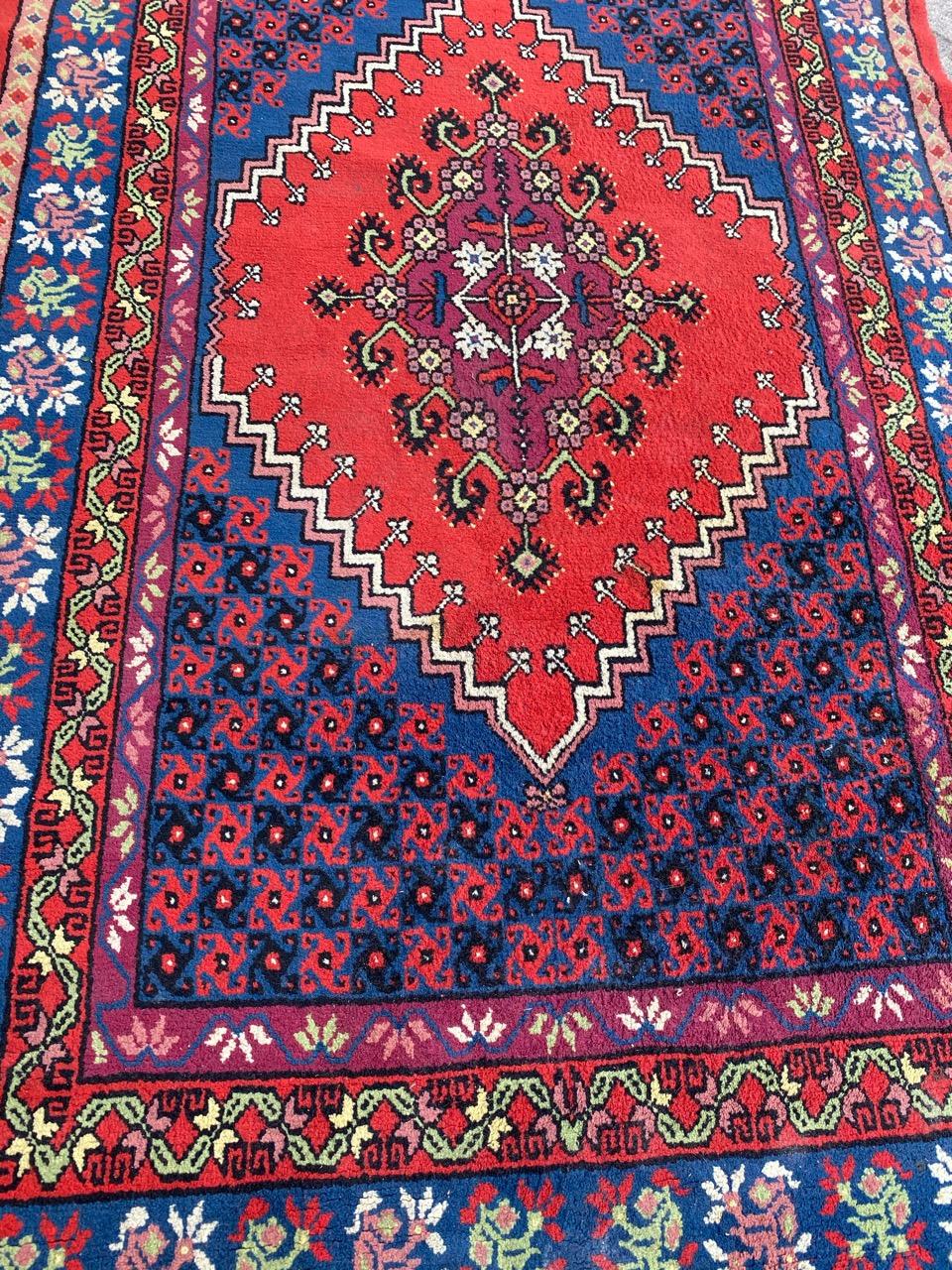 Exquis tapis tunisien de la fin du XXe siècle présentant un motif géométrique captivant et des couleurs vibrantes, notamment le rouge, le bleu, le vert et le violet. Ce chef-d'œuvre est méticuleusement noué à la main avec du velours de laine sur une