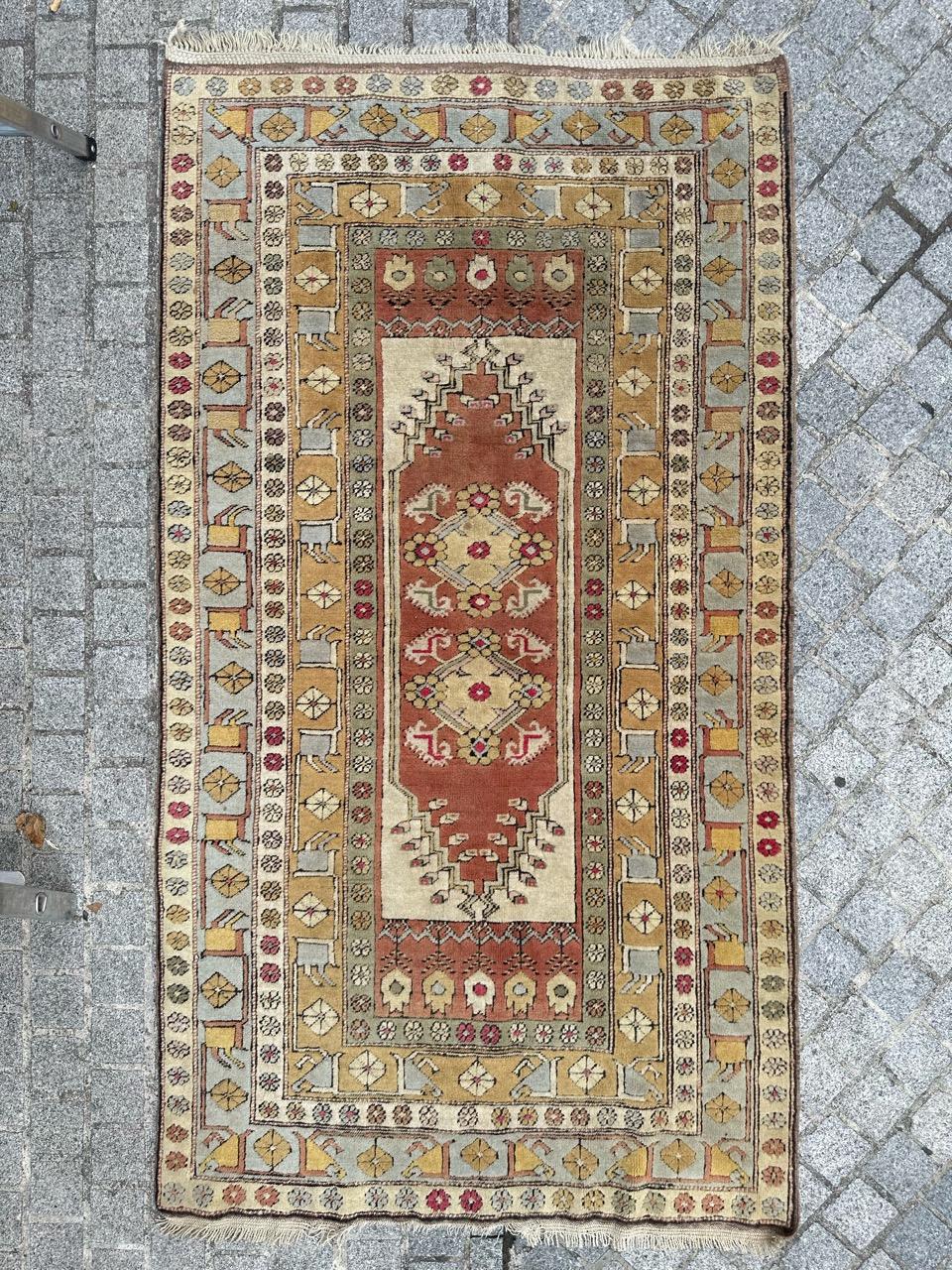 Entdecken Sie diesen exquisiten türkischen Teppich aus der Mitte des Jahrhunderts, ein wahres Meisterwerk der Handwerkskunst. Mit Präzision handgeknüpft aus weichem Wollsamt auf einem Wollfond, besticht er durch ein atemberaubendes geometrisches