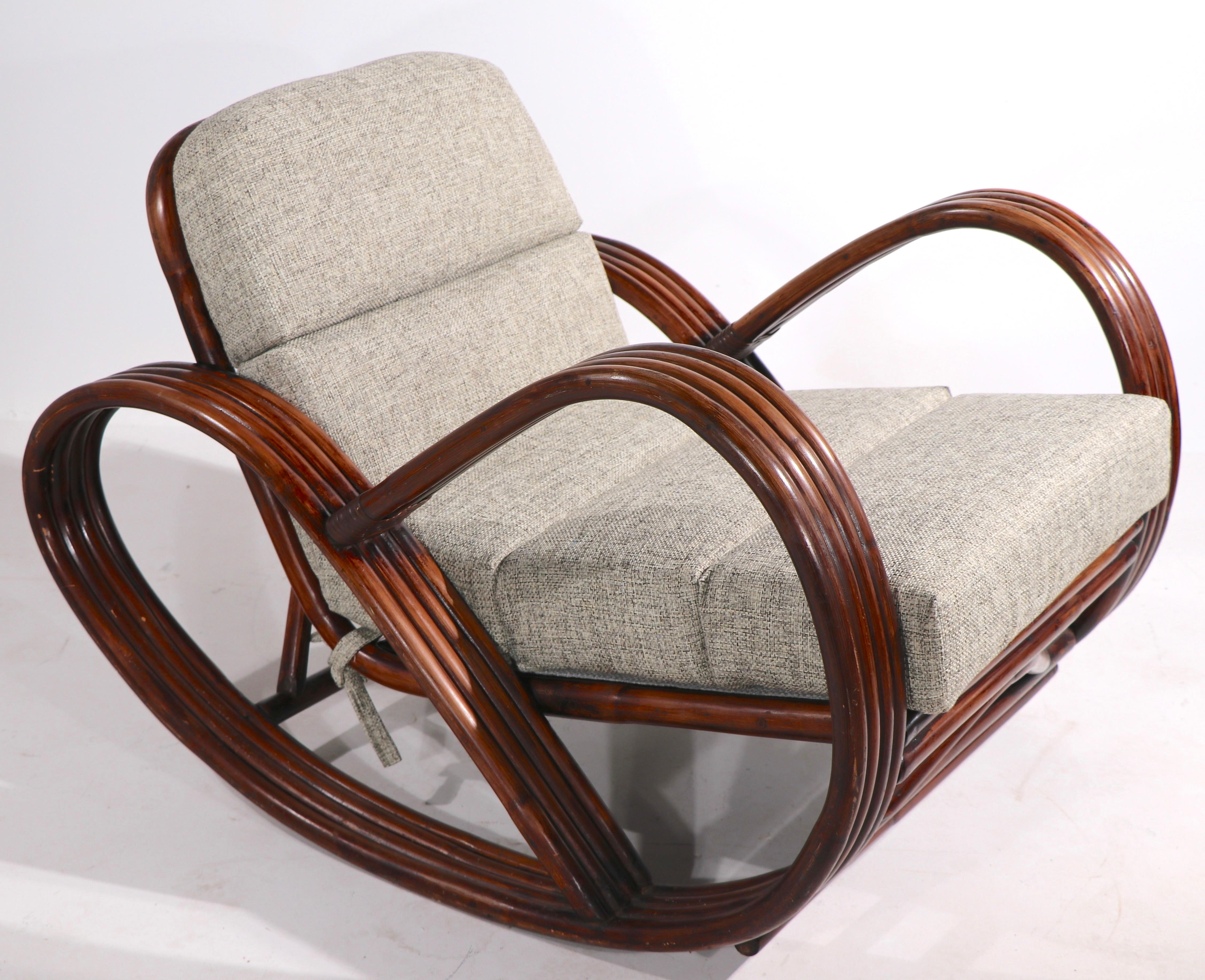 Chic, stylish and impressive four rung pretzel arm rocking, lounge chair in bamboo, with new gray tweed upholstery. Design reminiscent of Paul Frankl, circa 1940/1950's, clean ready to use condition. 
Measures: Total H 28 x Arm H 23.5 x Seat H 18
