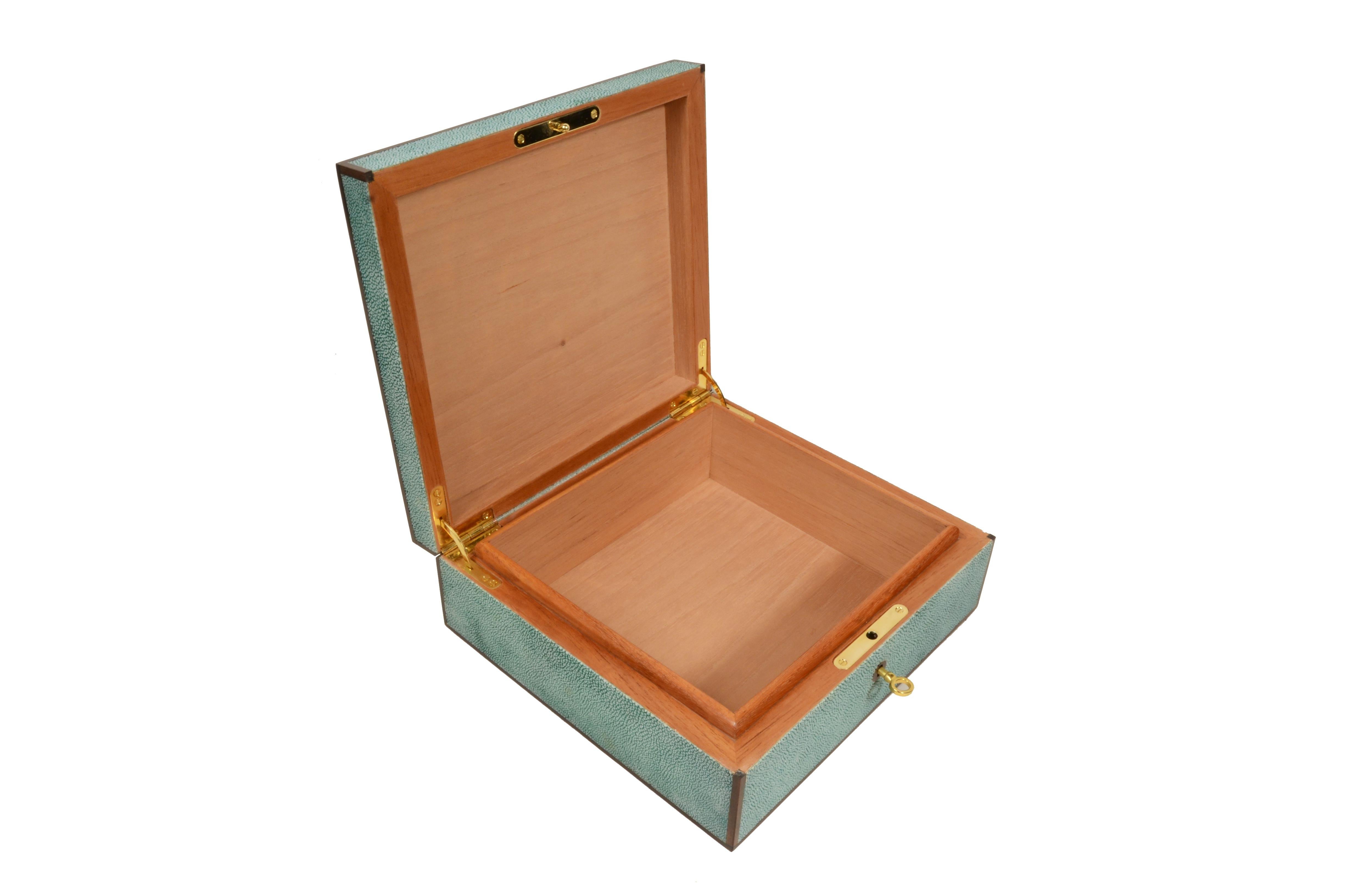Precious cigar box set  galuchat-coated teak wood with ebony profiles, 1970s manufacture.
Wooden teak base with slightly raised lid in the shape of a truncated pyramid  and masterfully veneered in Galuchat, purebred leather  emerald green tint with