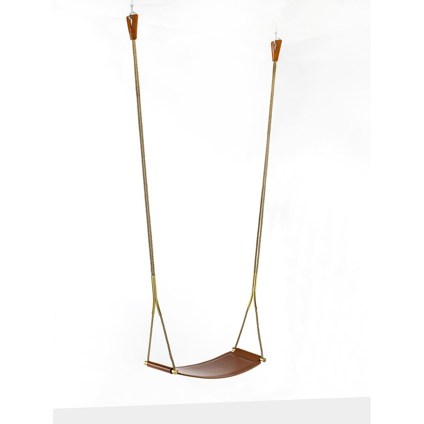 This indoor swing will add a sophisticated and playful accent to a modern loft with its brown leather seat embellished by tone-on-tone stitching. Suspended from an adjustable rope, this swing features polished bronzed brass hardware that adds a