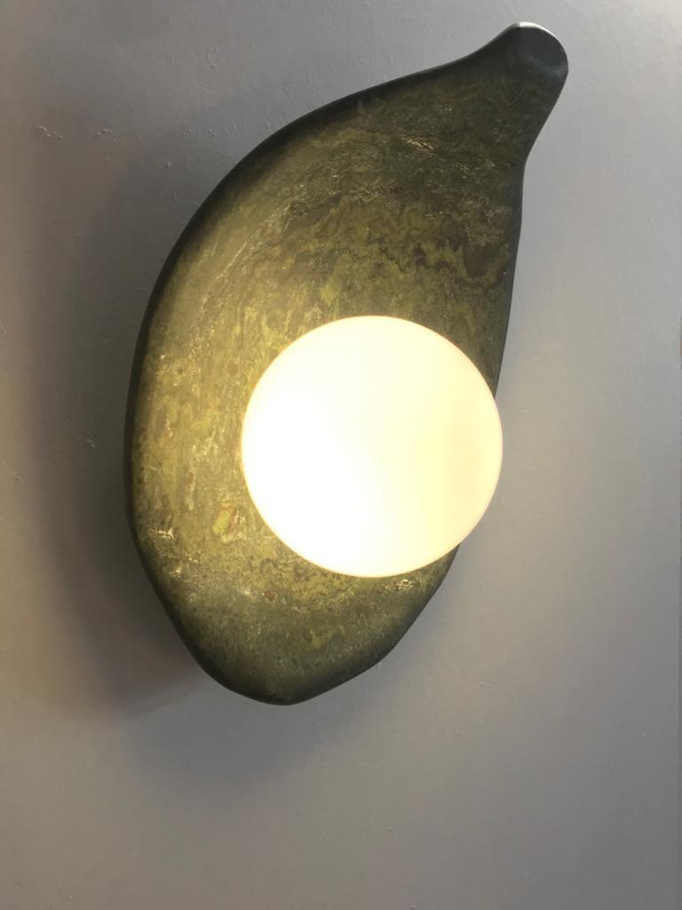 Prickless Pearl - 02 Sculpture Wall Lamp by ON.ENTROPY
Dimensions: W 18 x D 10 x H 6 cm
Materials: Green Marble.

on• entropy is a marble atelier established in 2009 in Athens and London with a focus on metamorphosis. Expanding from object to space