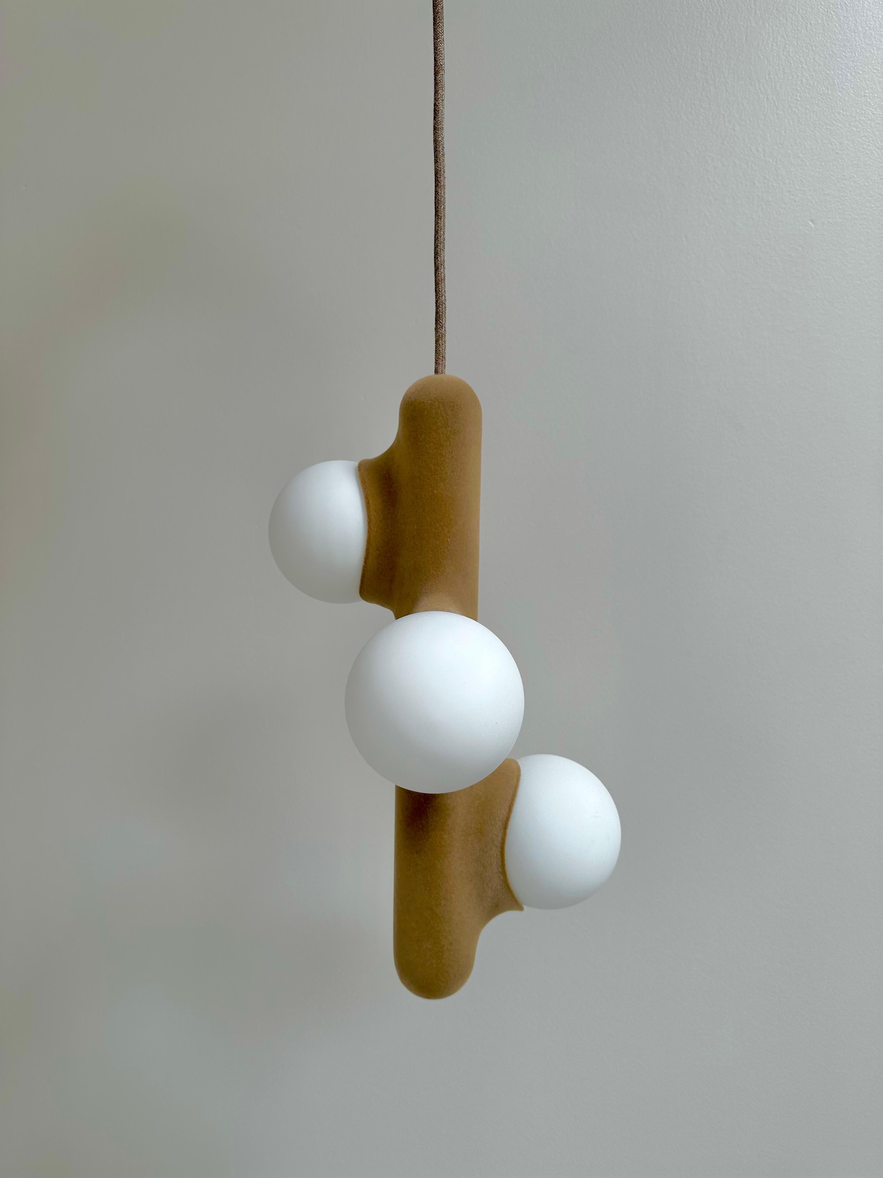 Lampada a sospensione con 3 opaline in velluto di fico d'India di Mickael Koska
Dimensioni: Ø 25 cm  x H. 300 cm.
Materiali: Vetro opalino, ceramica con finitura vellutata, finitura vellutata e Corde in tessuto.

Tutte le nostre lampade possono