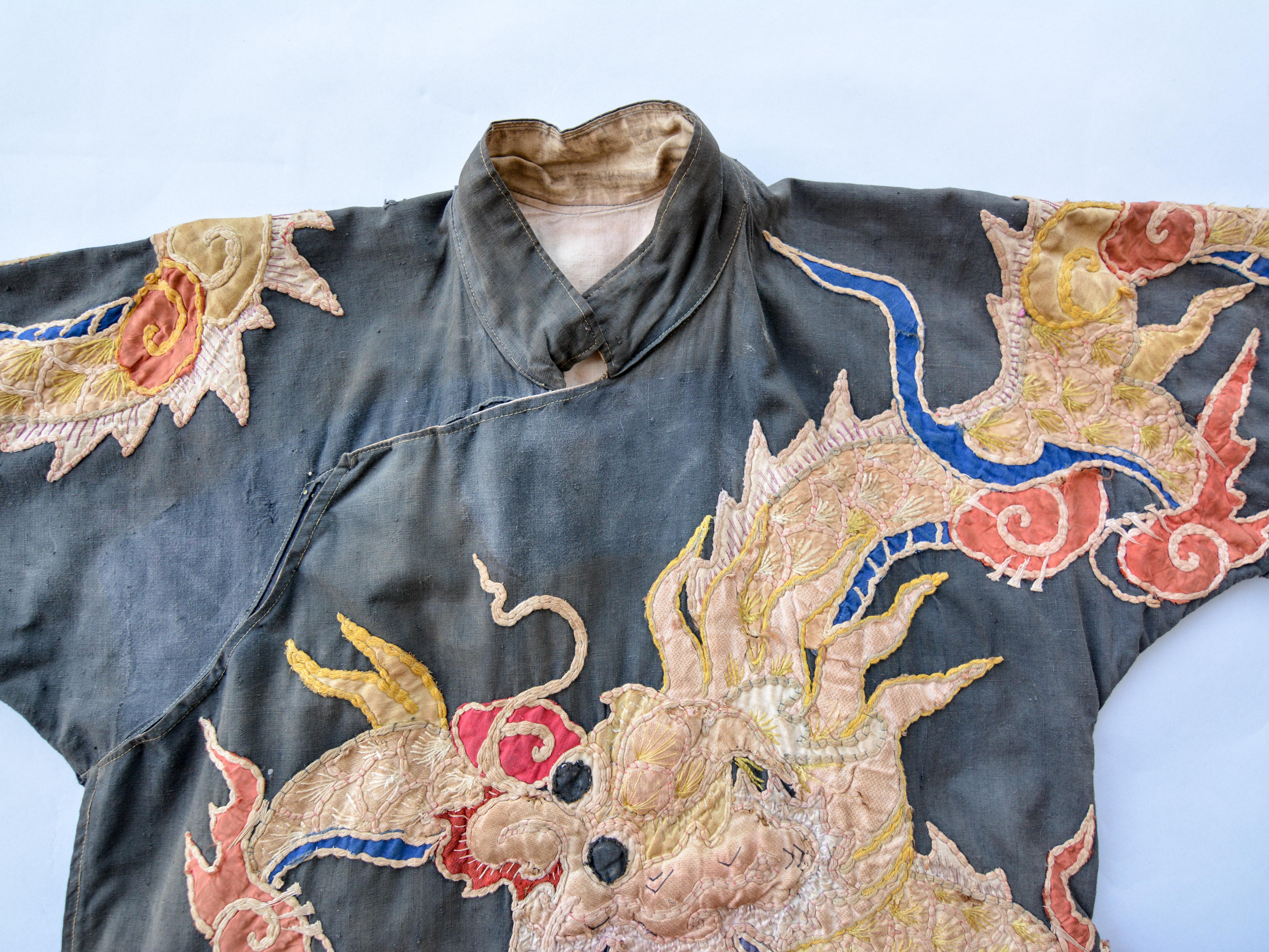 Priest or Shaman Coat. Southern China or Vietnam. Early to mid-20th century.
This visually impactful coat depicts as its central motif a dragon, on front and back, and utilizes embroidery and applique work.
The jacket is in fair condition. This is