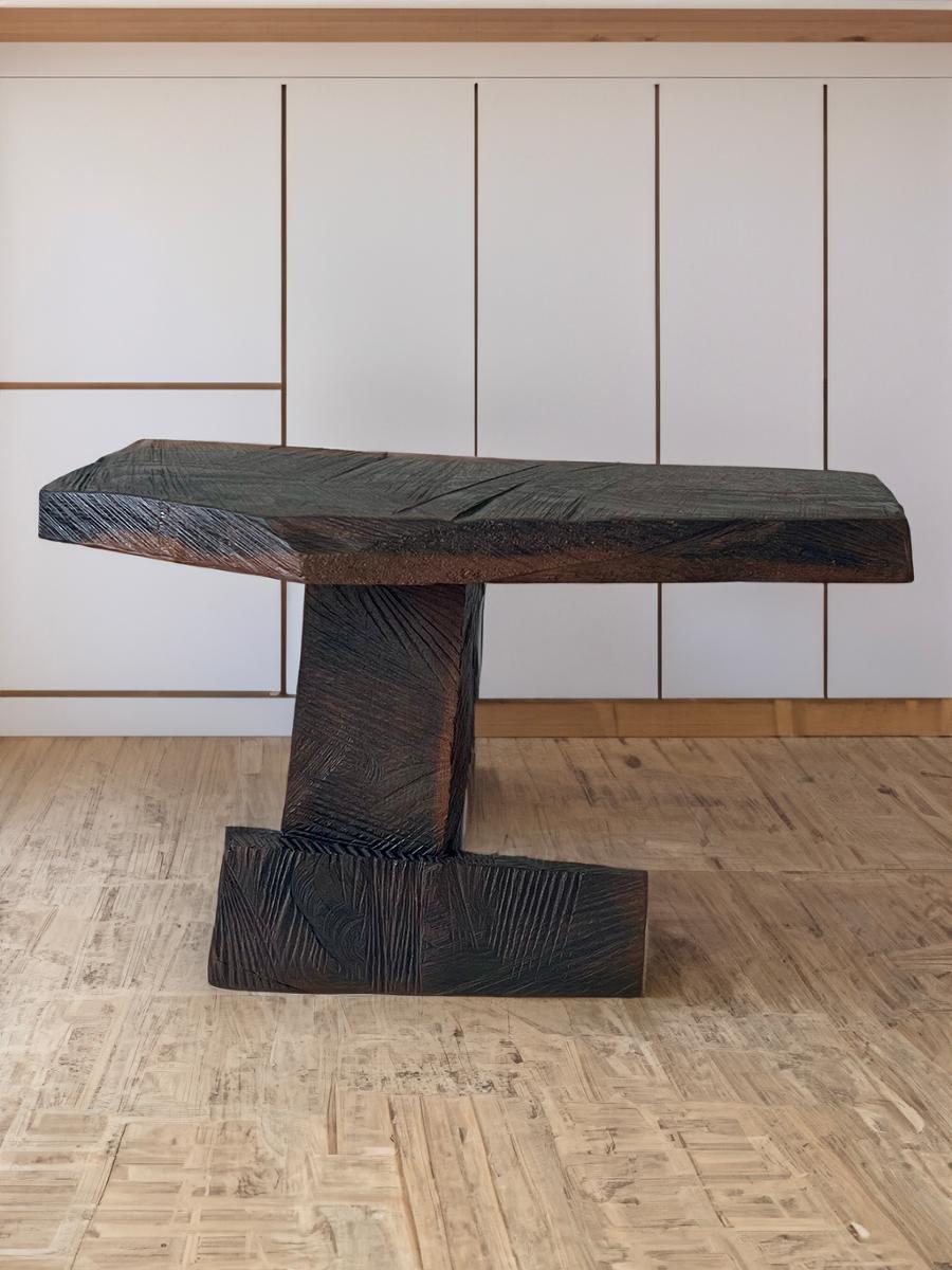Fabriquée en chêne richement oxydé, cette table d'appoint n'est pas seulement un meuble, mais une pièce d'apparat qui marie sans effort la forme et la fonction. D'une hauteur de 17 pouces, d'une largeur de 27 pouces et d'une profondeur de 12 pouces,