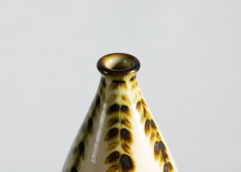 A stoneware vase by the famed French firm Primavera, this piece boasts a
glassy glaze and a soft bordered image of a stag in the woods.

Incised: PRIMAVERA / FRANCE.