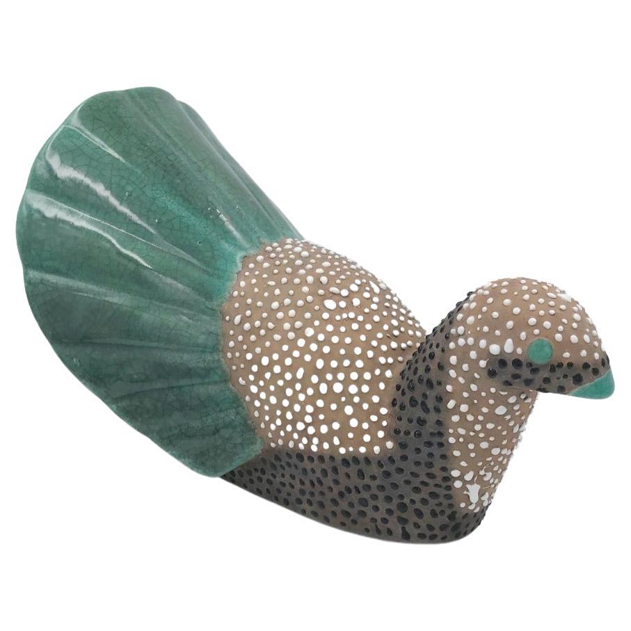 Primavera / PetitJean. Faraona stilizzata Art Decor in terracotta decorata.

Pianta di smalto bianco a puntini su tutto il corpo, tranne sul becco e sulla coda trattati con smalto liscio verde e nero. 
Firmato Primavera, Fabrice: CAB (Céramique