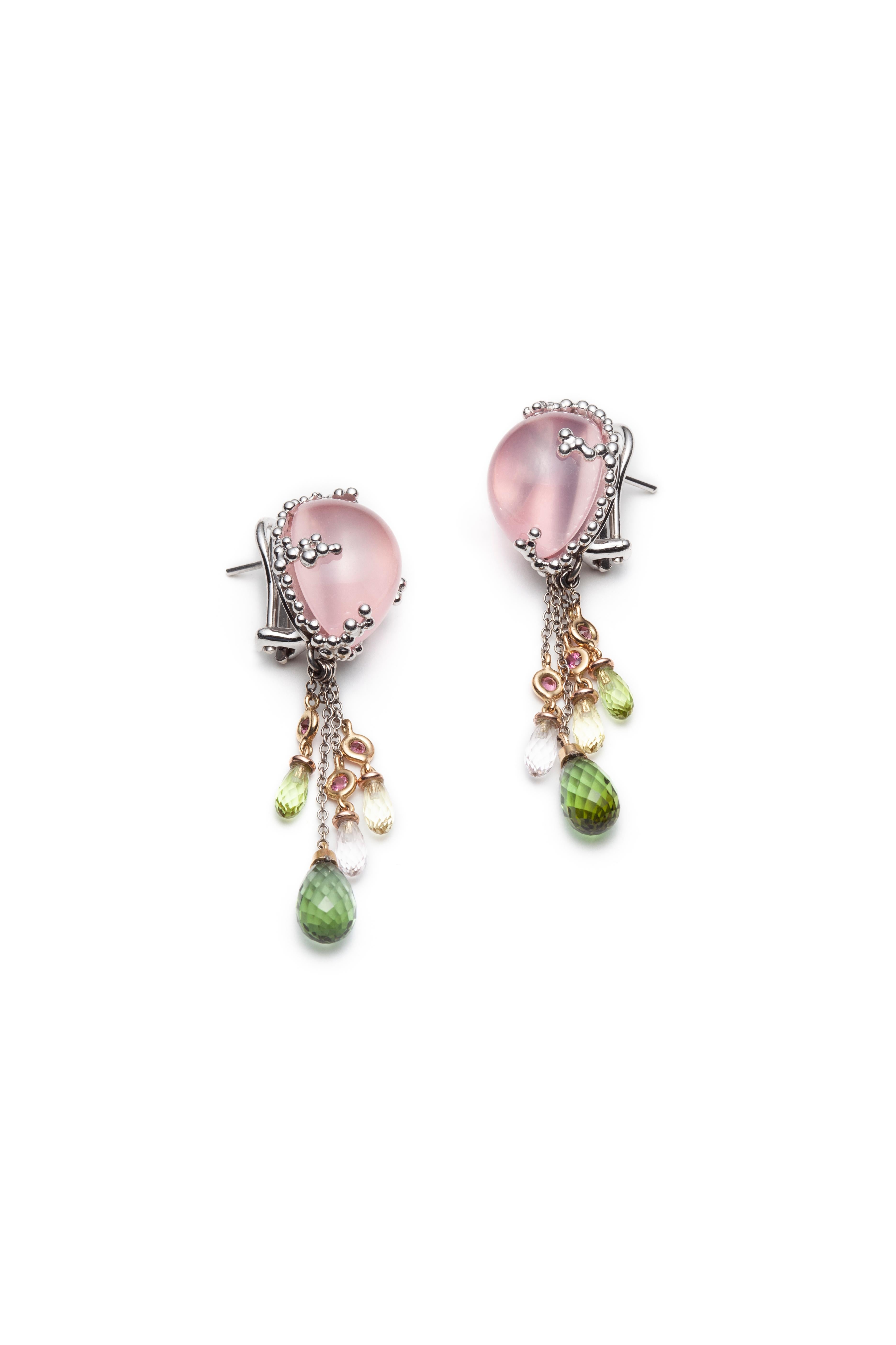 
The PRIMAVERA rose quartz earrings are made in 18k white, pink and yellow gold. The main stones, rose quartz cabochons are held in place by settings made of tiny white gold balls. Prasiolite quartz, peridot and tourmaline briolettes mounted with