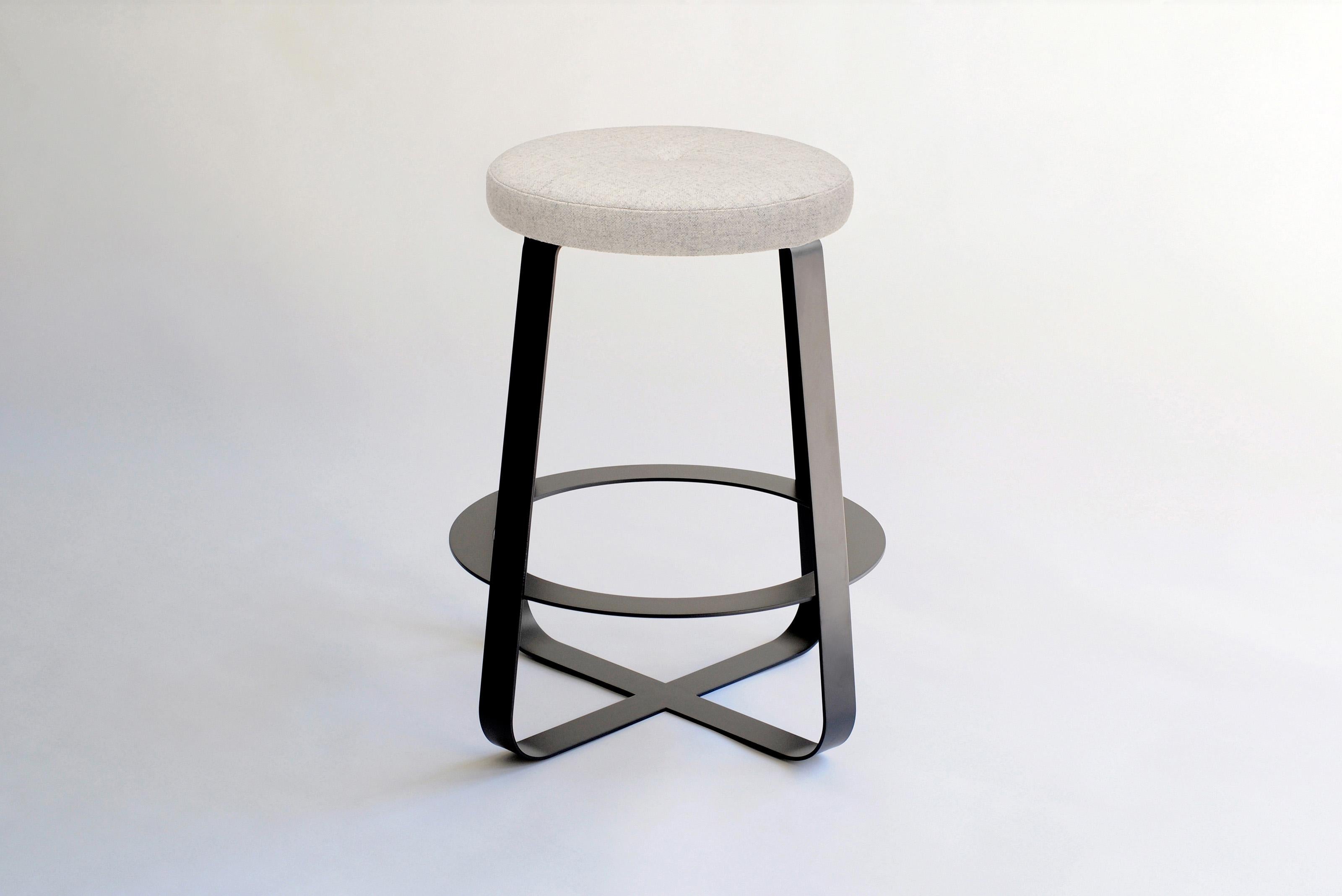 Primi Bar Stool by Phase Design
Dimensions: Ø 54.6 x H 73.7 cm. 
Materials: Powder-coated steel and upholstery.

Solid steel flat bar available in a flat black or white powder coat finish with carved walnut, white ash, or upholstered top. Powder