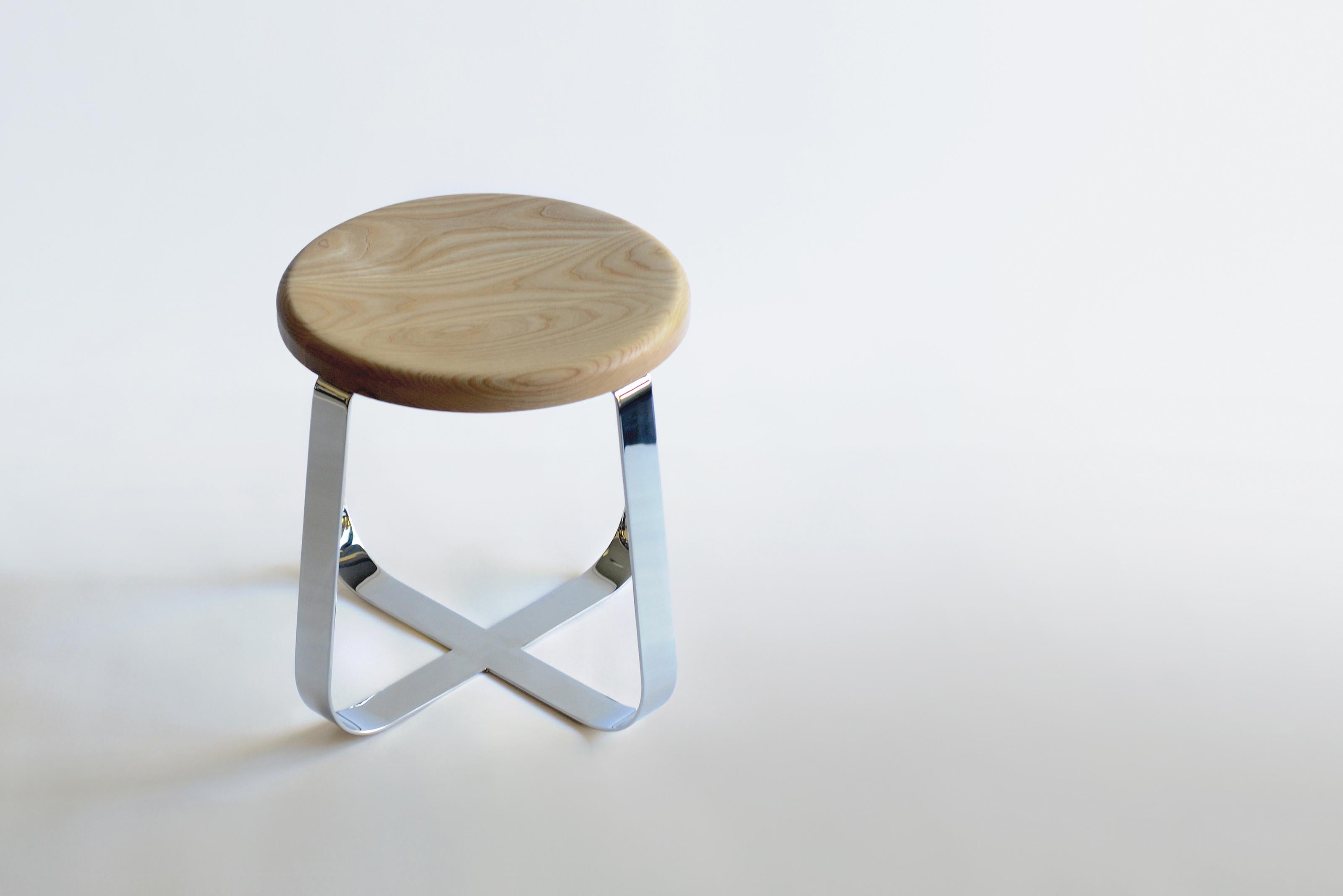 Primi Low Stool by Phase Design
Dimensions: Ø 48.3 x H 44.5 cm. 
Materials: Polished chrome and white ash.

Solid steel flat bar available in a flat black or white powder coat finish with CNC cut walnut, white ash, or upholstered top. Powder coat
