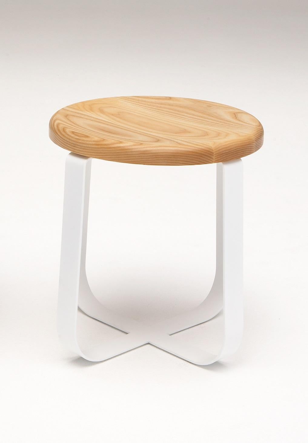 Primi Low Stool by Phase Design
Dimensions: Ø 48.3 x H 44.5 cm. 
Materials: Powder-coated steel and white ash.

Solid steel flat bar available in a flat black or white powder coat finish with CNC cut walnut, white ash, or upholstered top. Powder