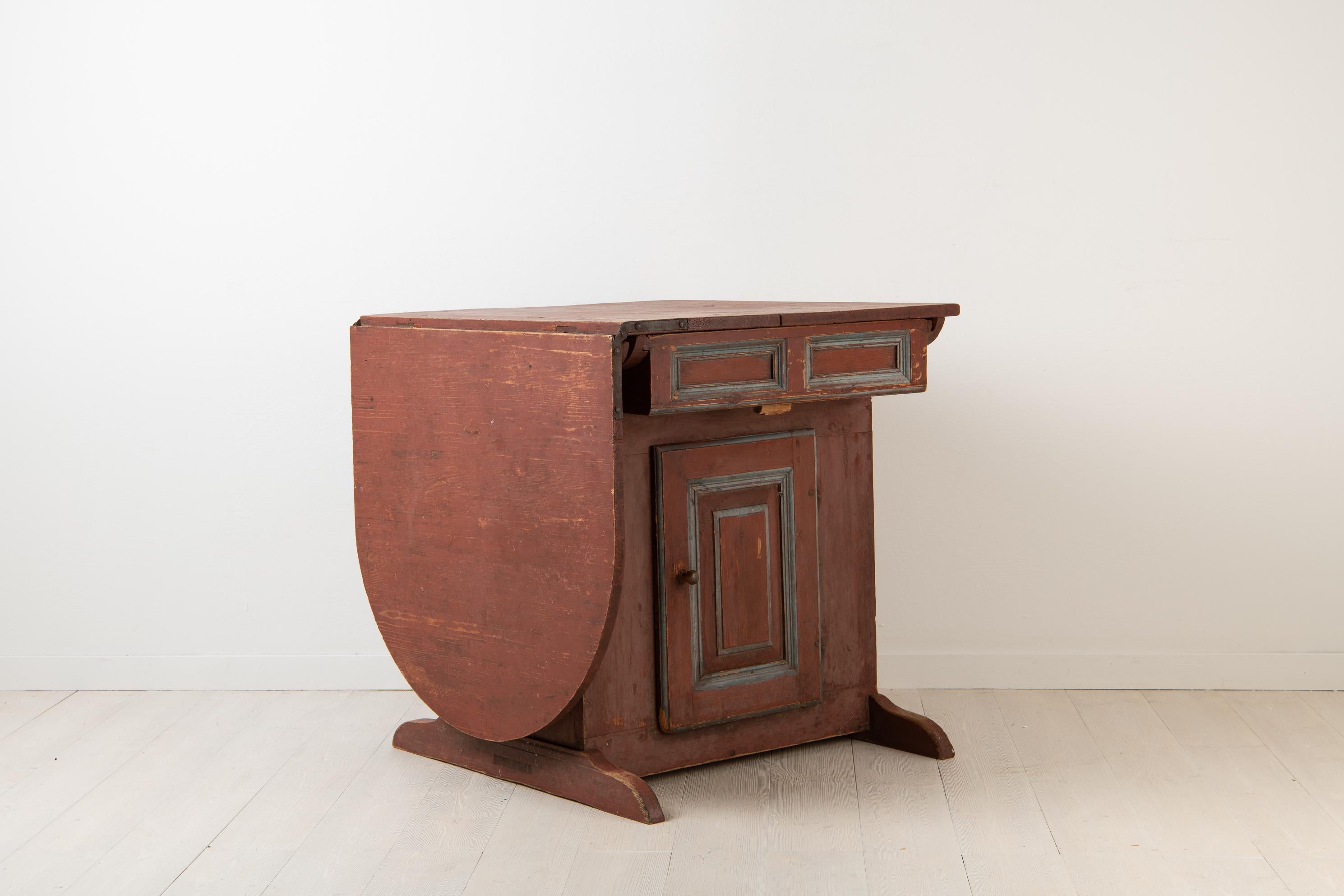 Primitive Folk Art table from Sweden. The table have most likely been used as a wall table or a window table where it is placed just underneath the windowsill. The locking mechanism to the door is unusual as it is made completely from wood - see