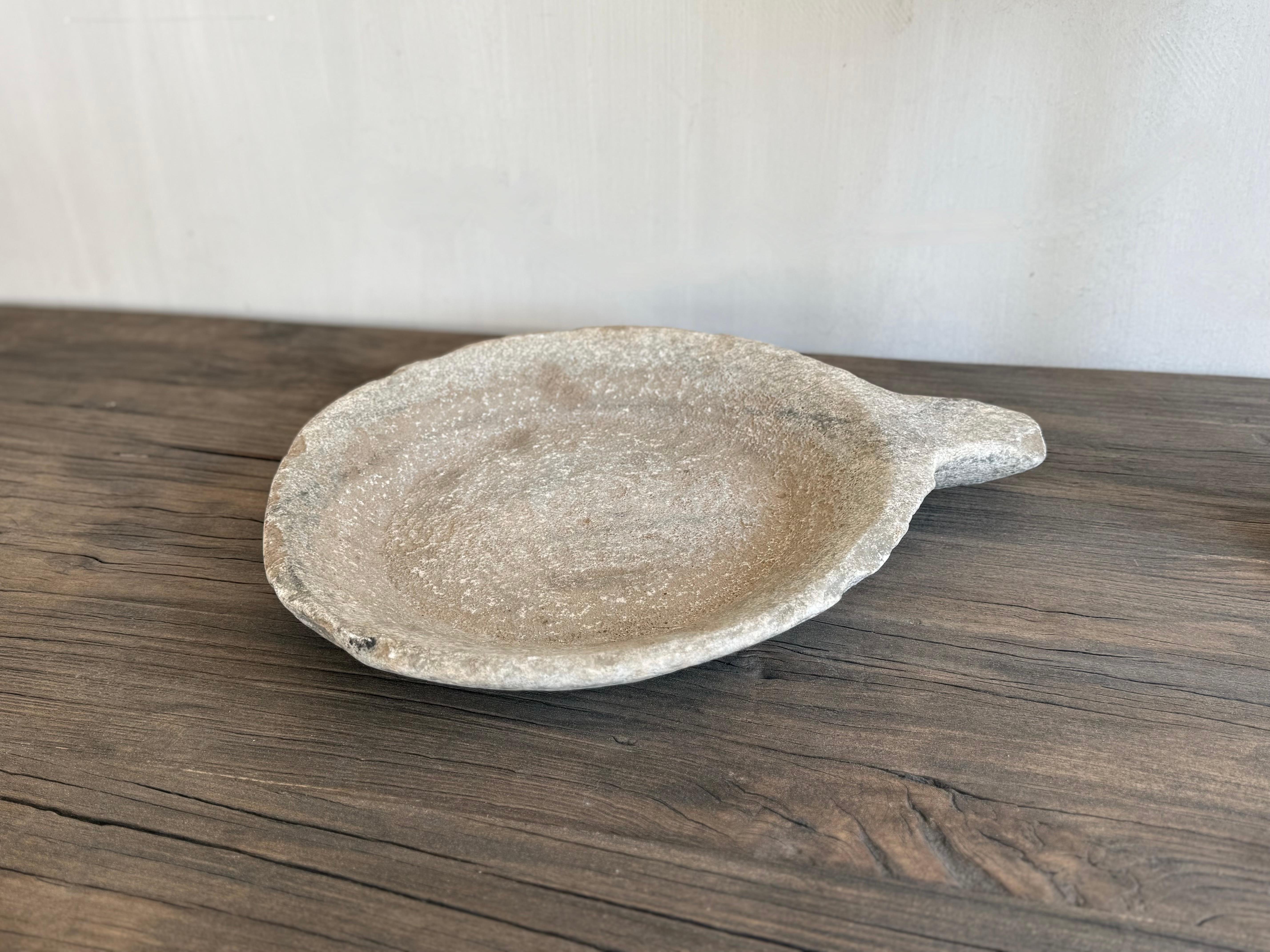 Splendida ciotola nepalese rovinata dagli agenti atmosferici a causa dell'età e dell'uso, di colore beige-grigio tenue. Molto neutrale.

Patina e struttura impressionanti dovute all'uso.
La ciotola misura 34 cm e con il manico aggiuntivo 42