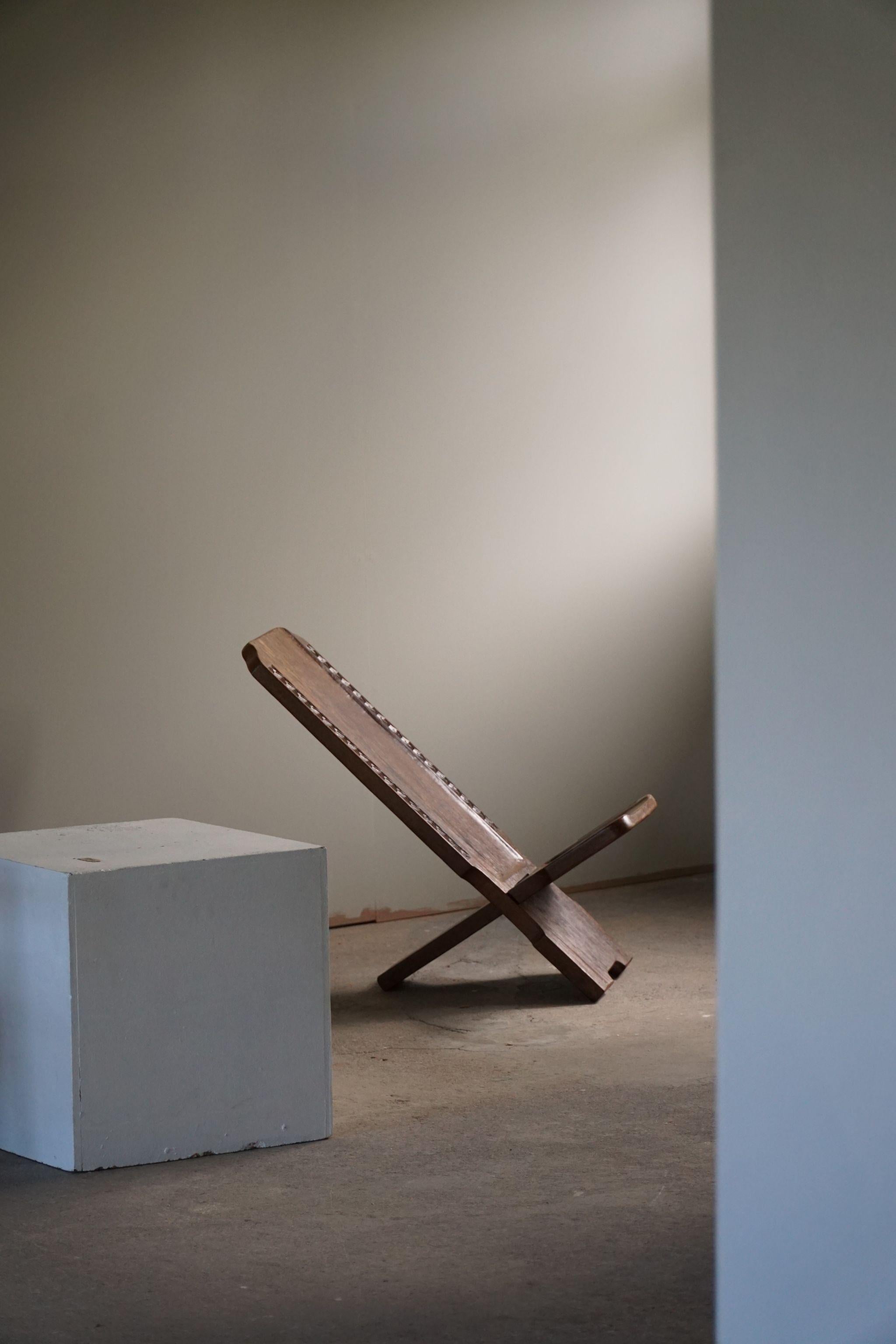 Magnifique chaise pliante africaine en bois massif sculptée à la main. La chaise à palabre est un type de mobilier africain traditionnel. Magnifiquement fabriqué à la main et décoré de motifs géométriques..

Un bel objet wabi sabi avec une belle