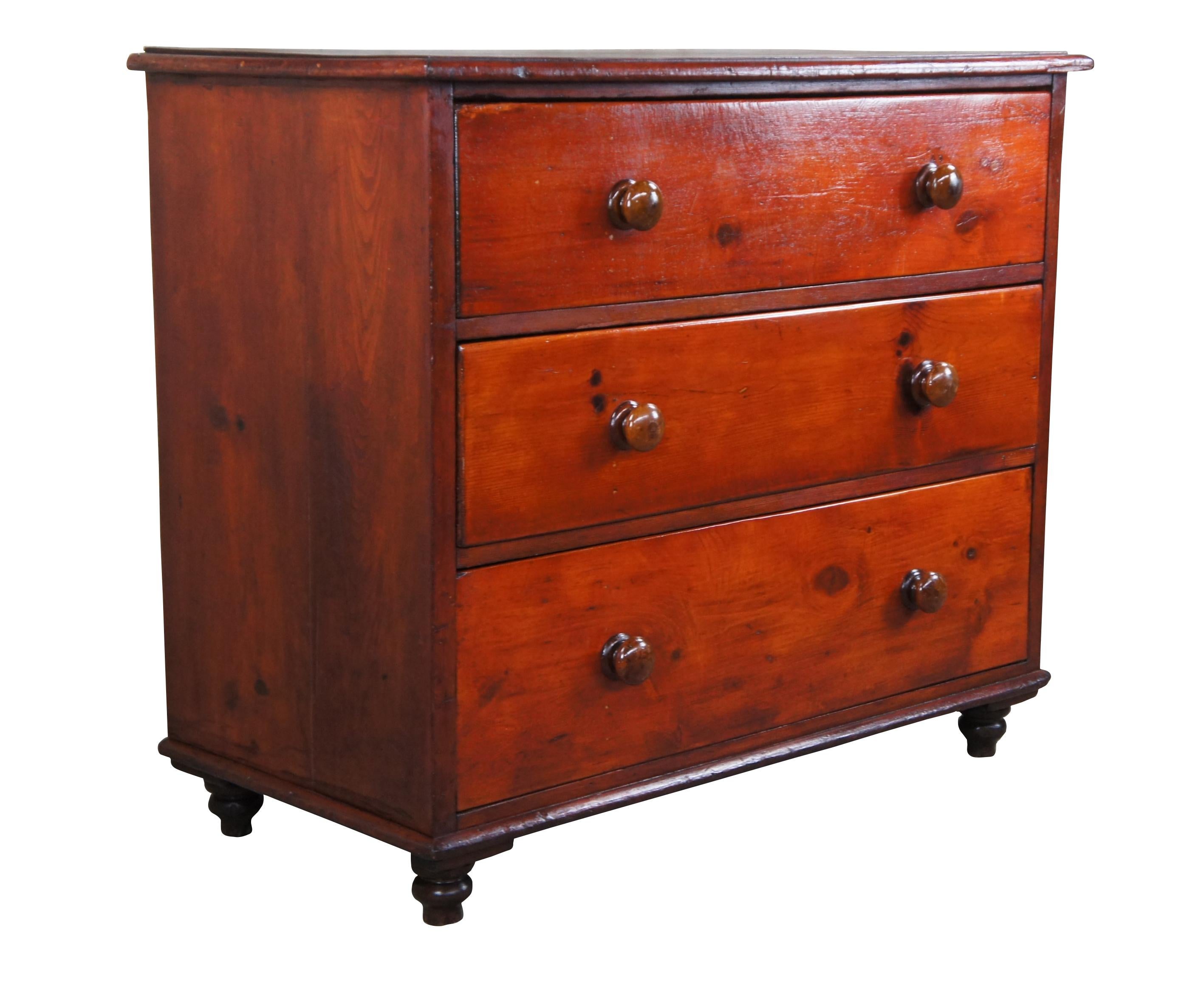 English pine chest of drawers, circa 1870s. Features a glowing patina with three hand dovetailed divided drawers and wooden turned handles. The case is supported by hand turned peg legs. Great for use in an entry or as a console. A charming